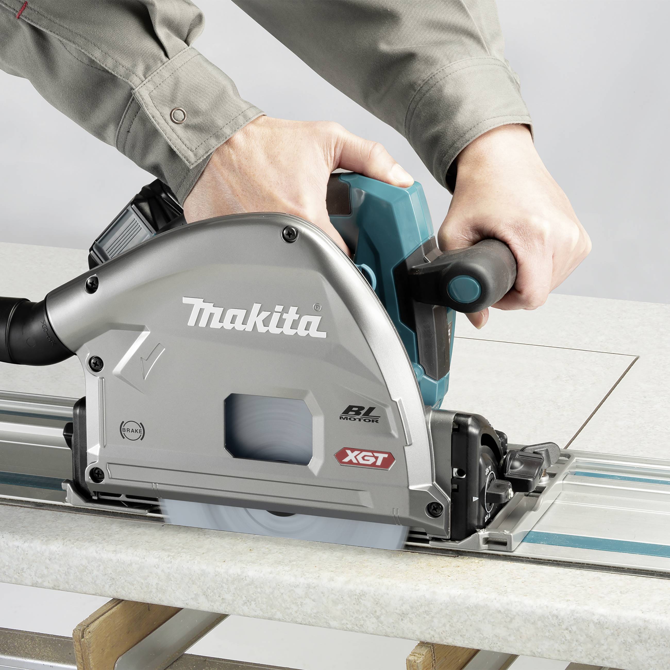 Eine Person schneidet mit einer Handkreissäge präzise eine Holzplatte. Die Maschine ist von der Marke Makita mit XGT-Technologie.