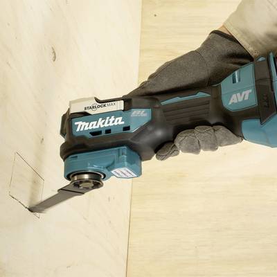 Eine Hand hält ein Elektrowerkzeug auf einer Holzplatte und schneidet ein Loch hinein. Das Werkzeug ist schwarz-türkis.