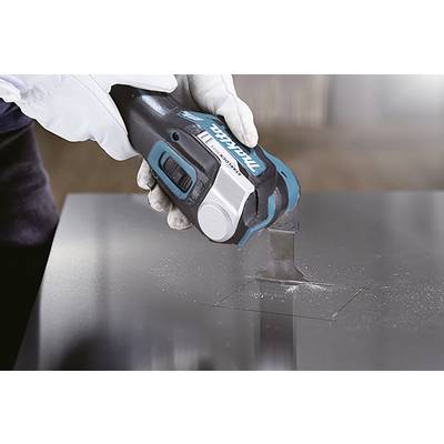 Eine Person in Handschuhen verwendet ein elektrisches Schneidwerkzeug, um ein quadratisches Loch in eine Metallplatte zu schneiden.