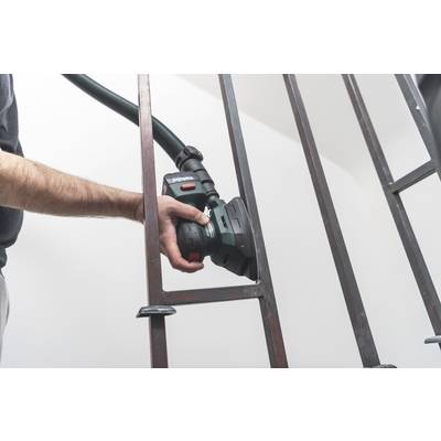 Person schleift Metallrahmen mit einer elektrischen Schleifmaschine. Arbeitsumgebung wirkt sauber und gut beleuchtet.