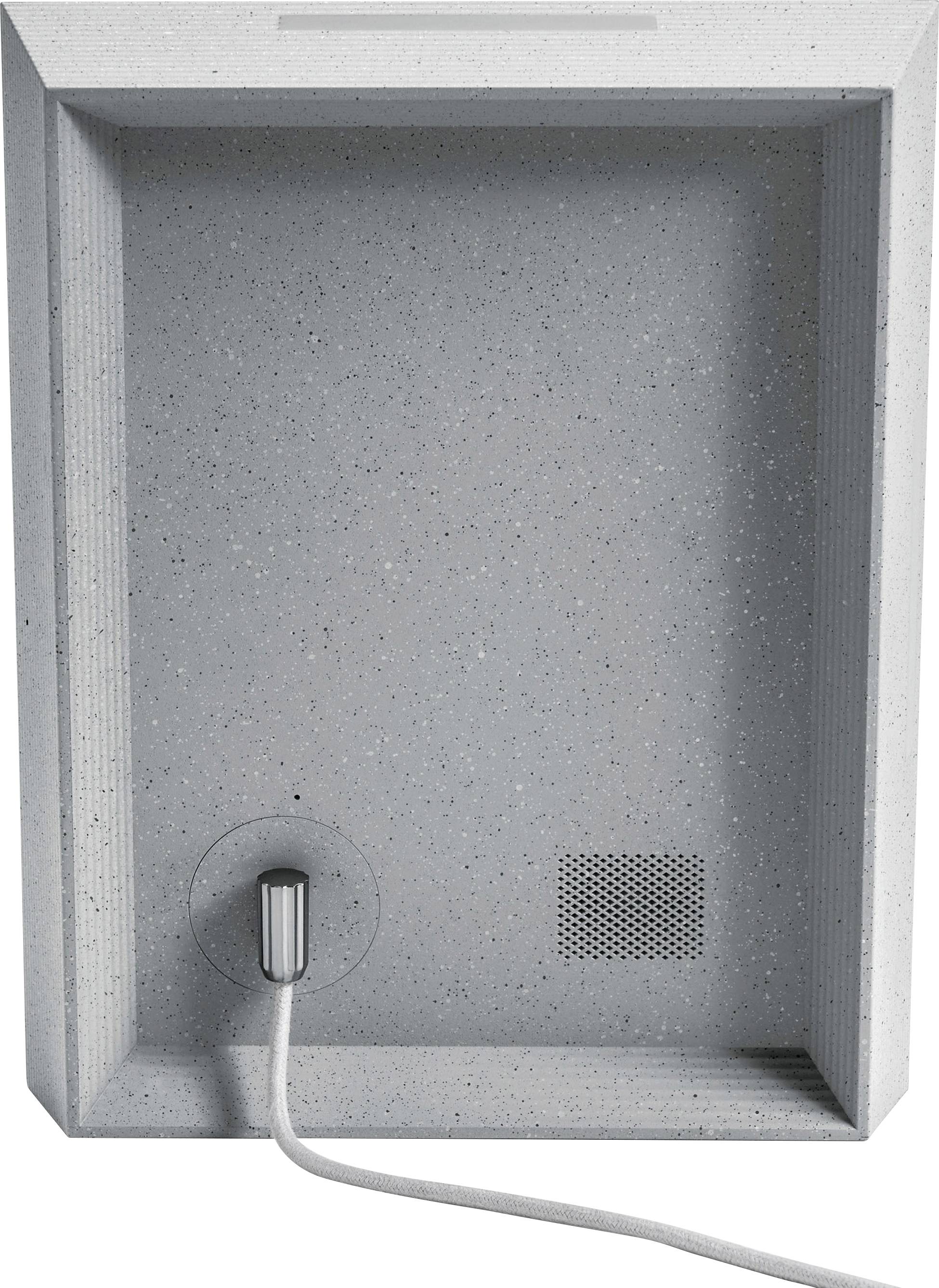 Ein grauer Briefkasten aus Beton mit rechteckigem Rahmen. Er hat einen Einwurfschlitz oben und ein unten herausragendes Kabel.