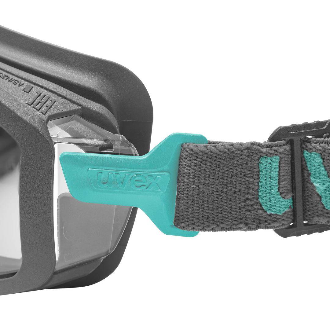 Eine schwarze Schutzbrille mit grauem Band und türkisfarbenem Verschluss, der die Aufschrift 'uvex' trägt.