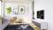 Helles Wohnzimmer mit grauem Sofa, rundem Tisch, grünem Sessel und großem Fernseher auf weißem Sideboard, dekoriert mit Pflanzen und Bildern.