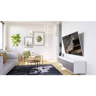 Helles Wohnzimmer mit modernen Möbeln, grünem Sessel, Wandkunst und großem Flachbildfernseher an der rechten Wand.