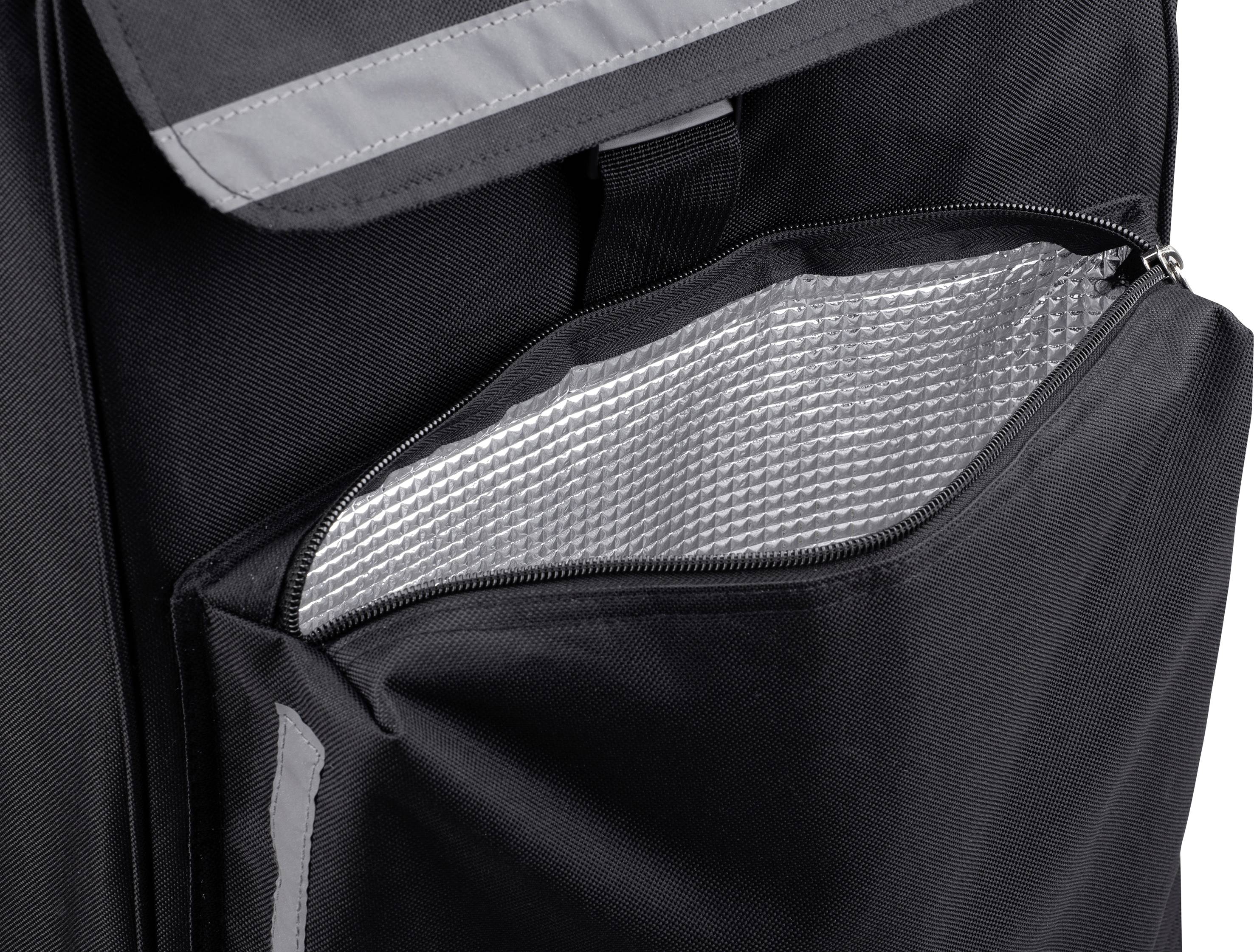 Der Reißverschluss einer Tasche ist teilweise geöffnet und zeigt ein silbernes, isolierendes Material im Inneren. Die Tasche ist schwarz.