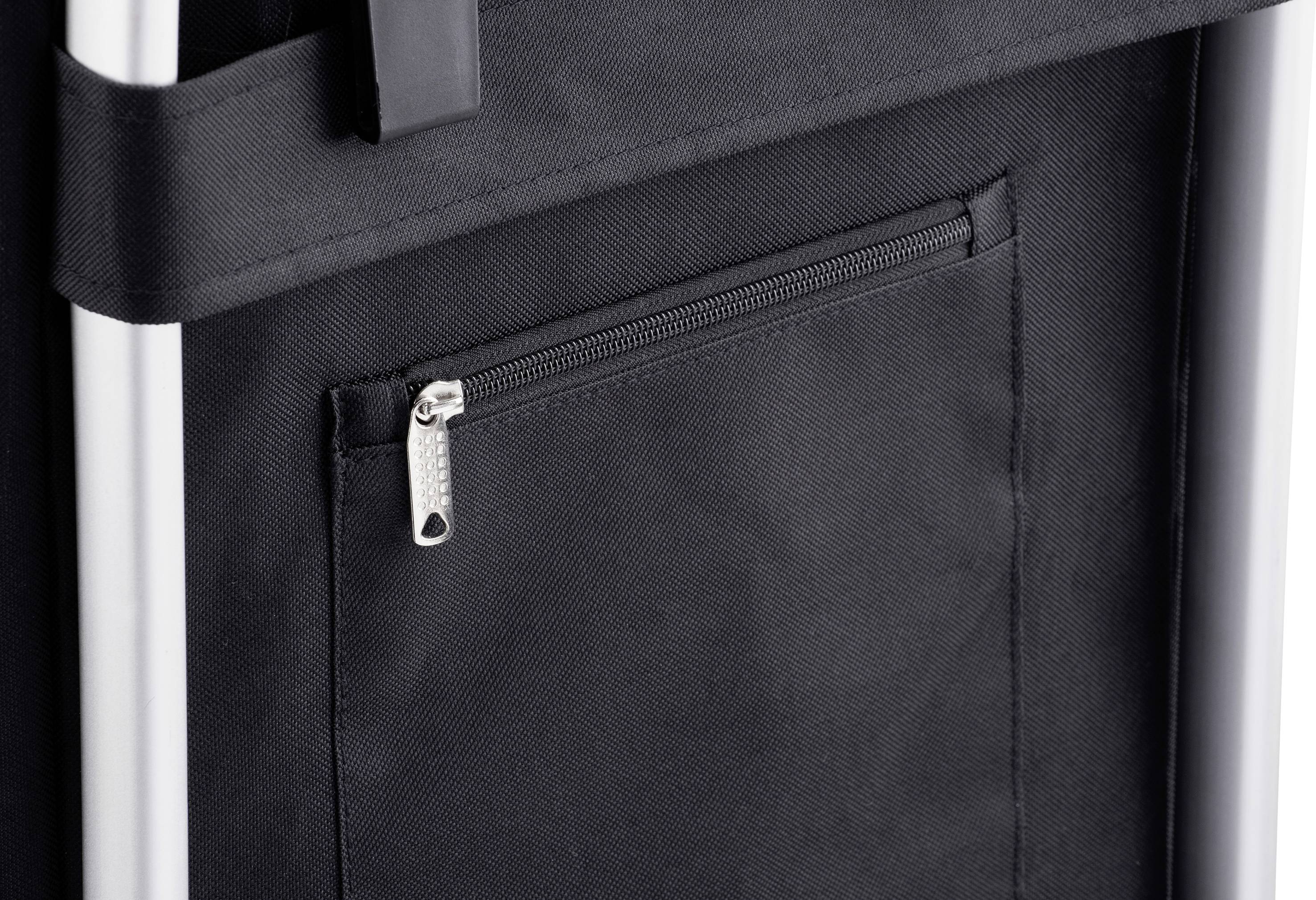 Nahaufnahme einer schwarzen Tasche mit einem silbernen Reißverschluss. Die Tasche ist an einem weißen Rahmen befestigt.