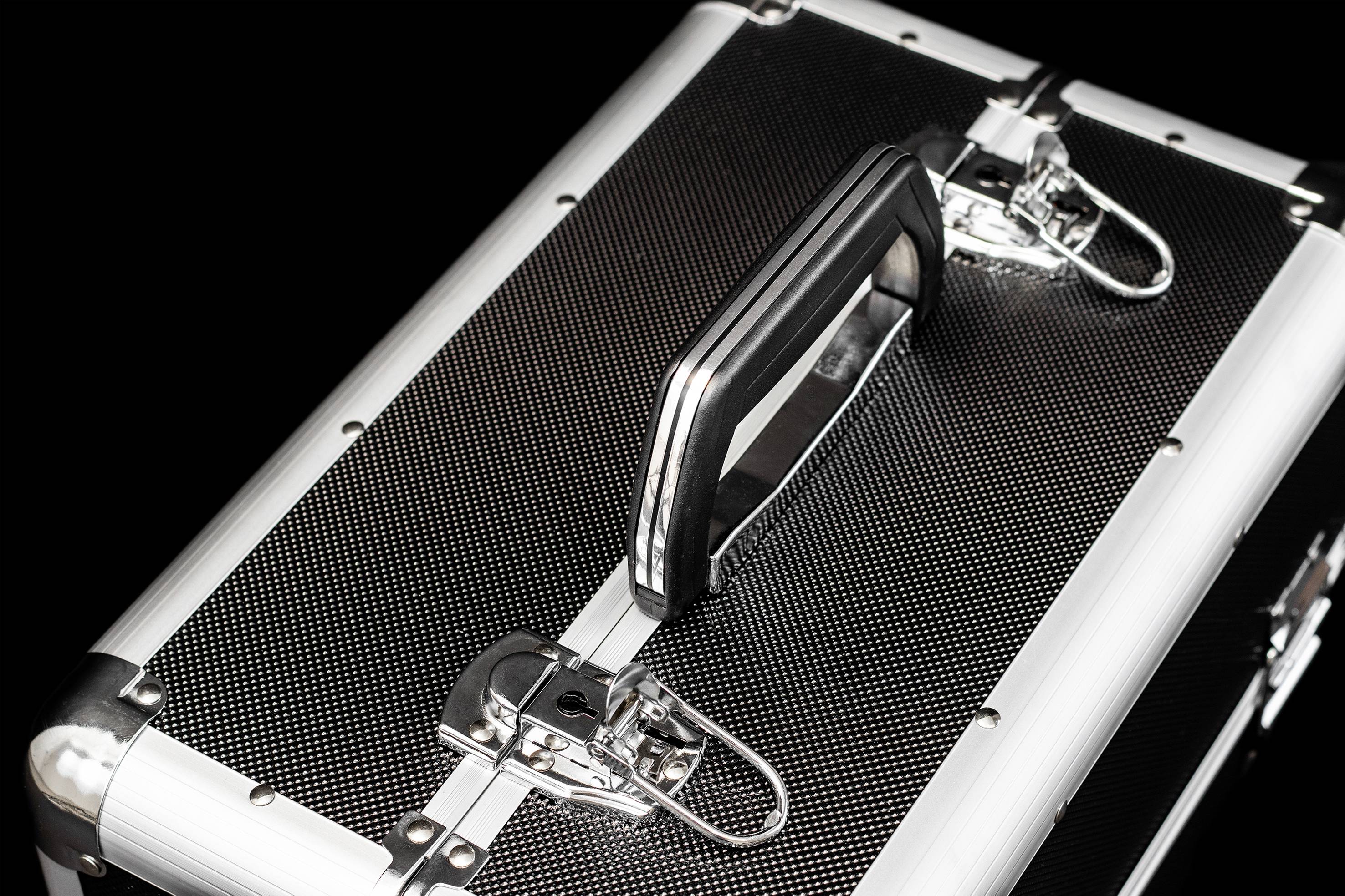 Ein silberner Koffer mit schwarzer Oberfläche und stabilen Verschlüssen, möglicherweise für den sicheren Transport von wertvollem Inhalt.