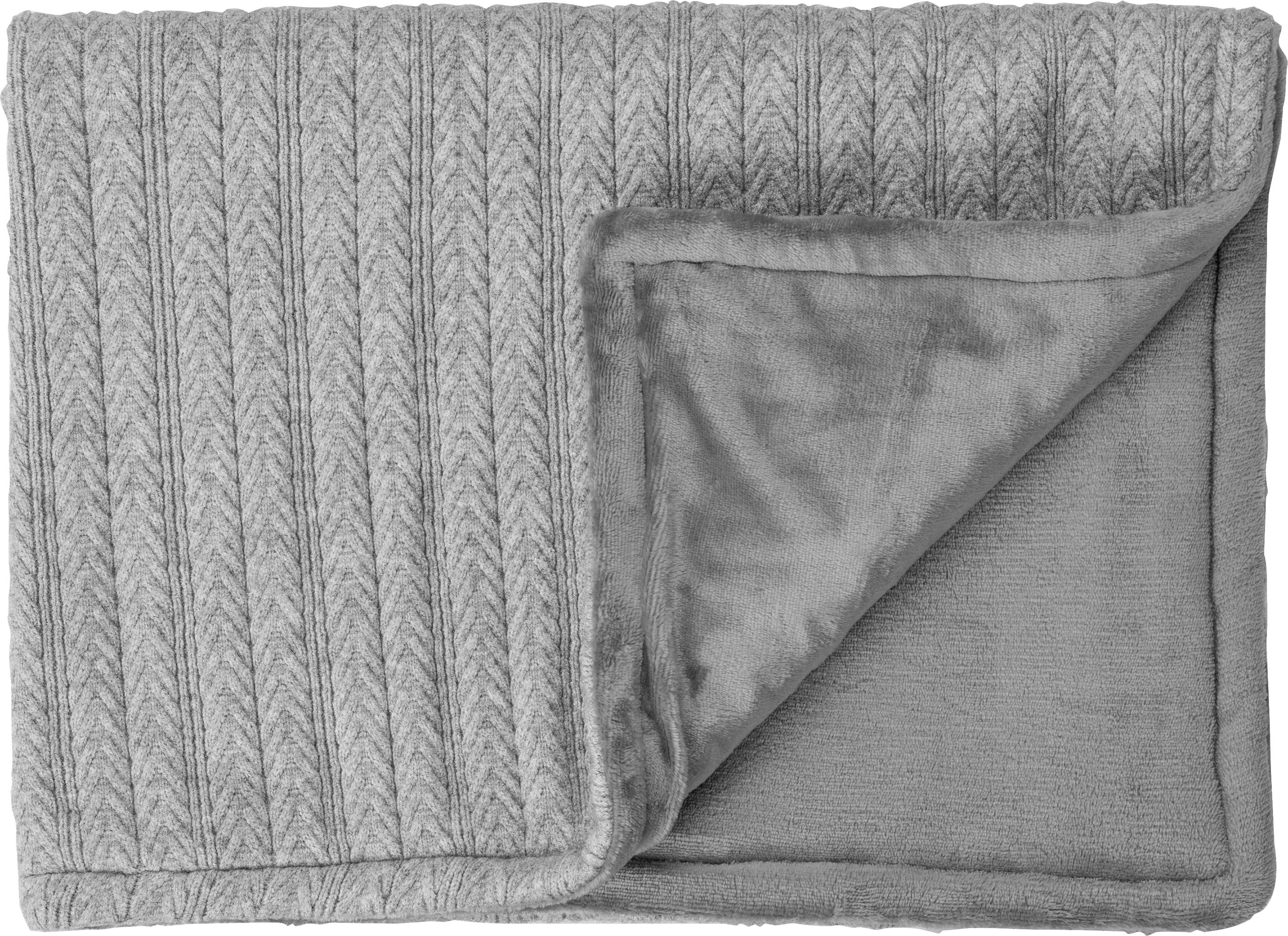 Grau gestrickte Decke, gefaltet mit gefütterter Innenseite. Die Textur zeigt ein Fischgrätenmuster.