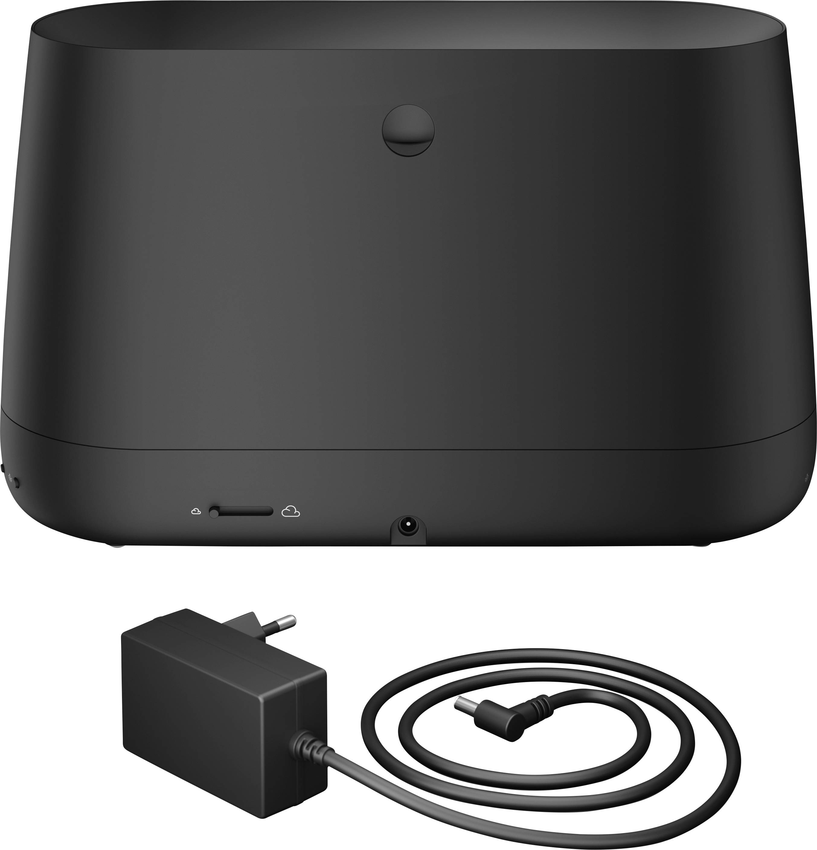 Schwarze Lautsprechereinheit mit Ladeanschluss und Netzkabel, im Vordergrund liegt ein abnehmbares Netzteil mit Kabel.