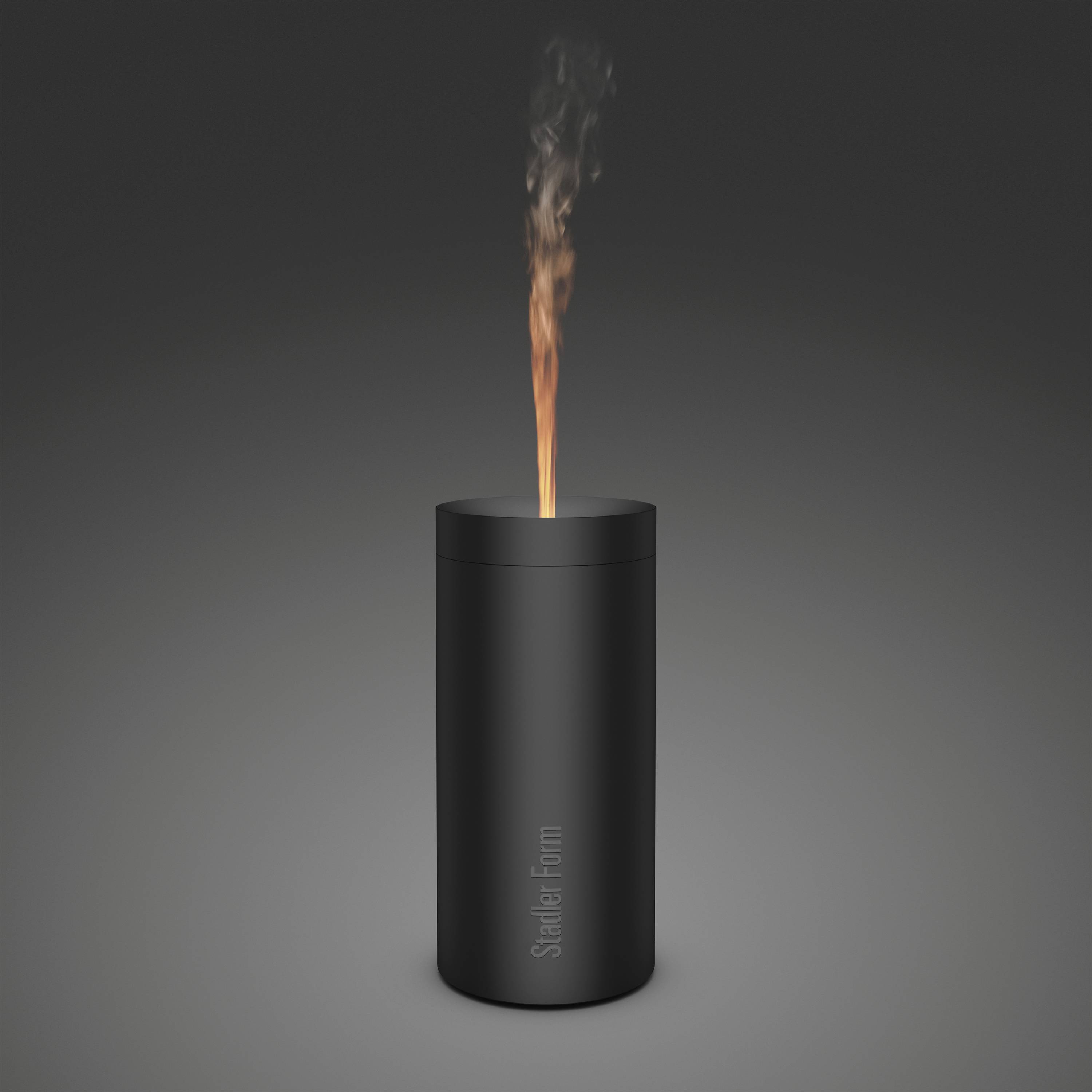 Ein schwarzer, zylindrischer Luftbefeuchter mit einer Flamme, die aus der Oberseite lodert, auf grauem Hintergrund.