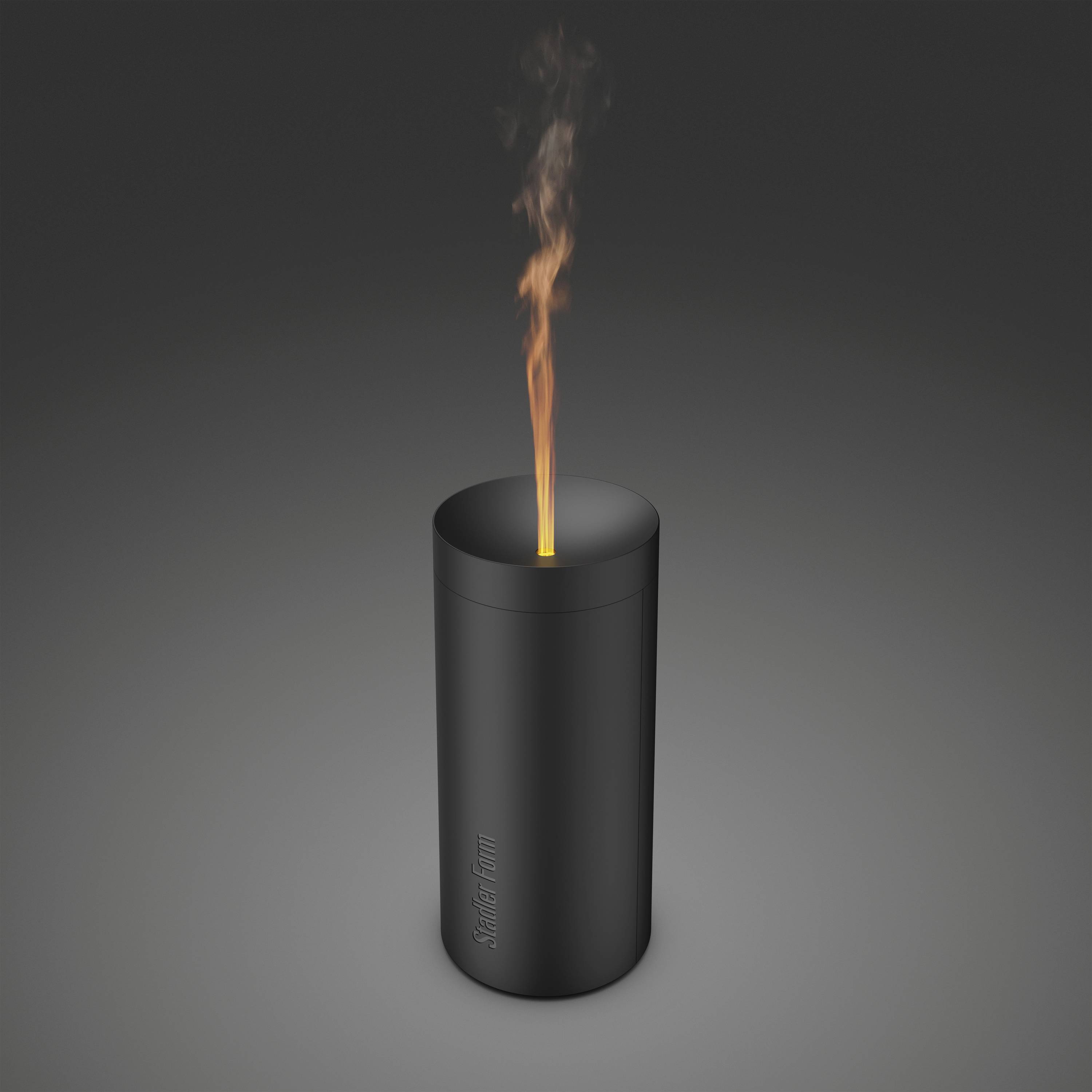 Eine schwarze, zylindrische Duftkerze mit einer brennenden Flamme auf dunklem Hintergrund. Die Flamme erzeugt einen Lichtschein.