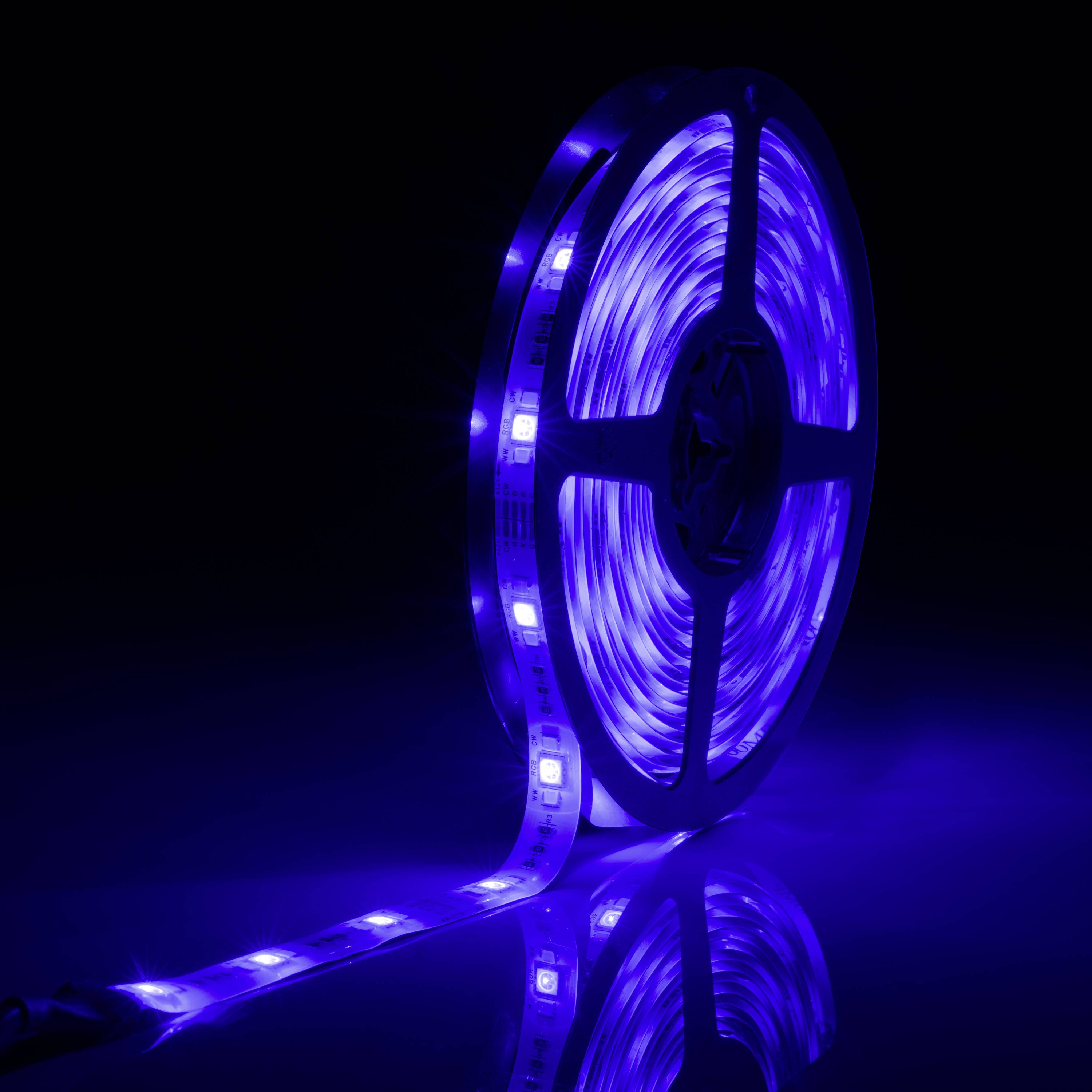 LED-Lichtstreifen aufgerollt, leuchtet in intensivem Blau auf dunklem Hintergrund.