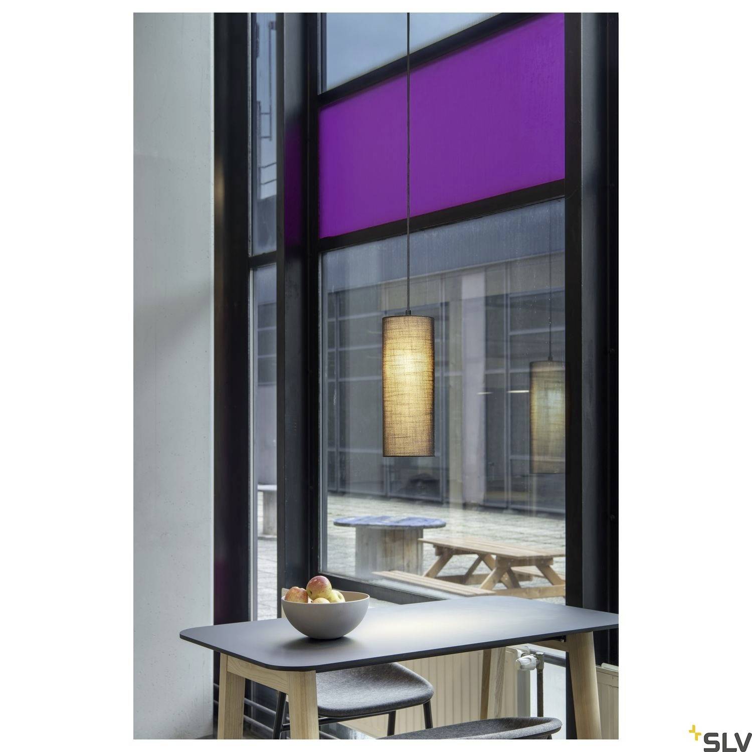 'Modernes Esszimmer mit großem Fenster, hölzernem Tisch und Stühlen. Hängelampe beleuchtet eine Schale mit Früchten auf dem Tisch.'