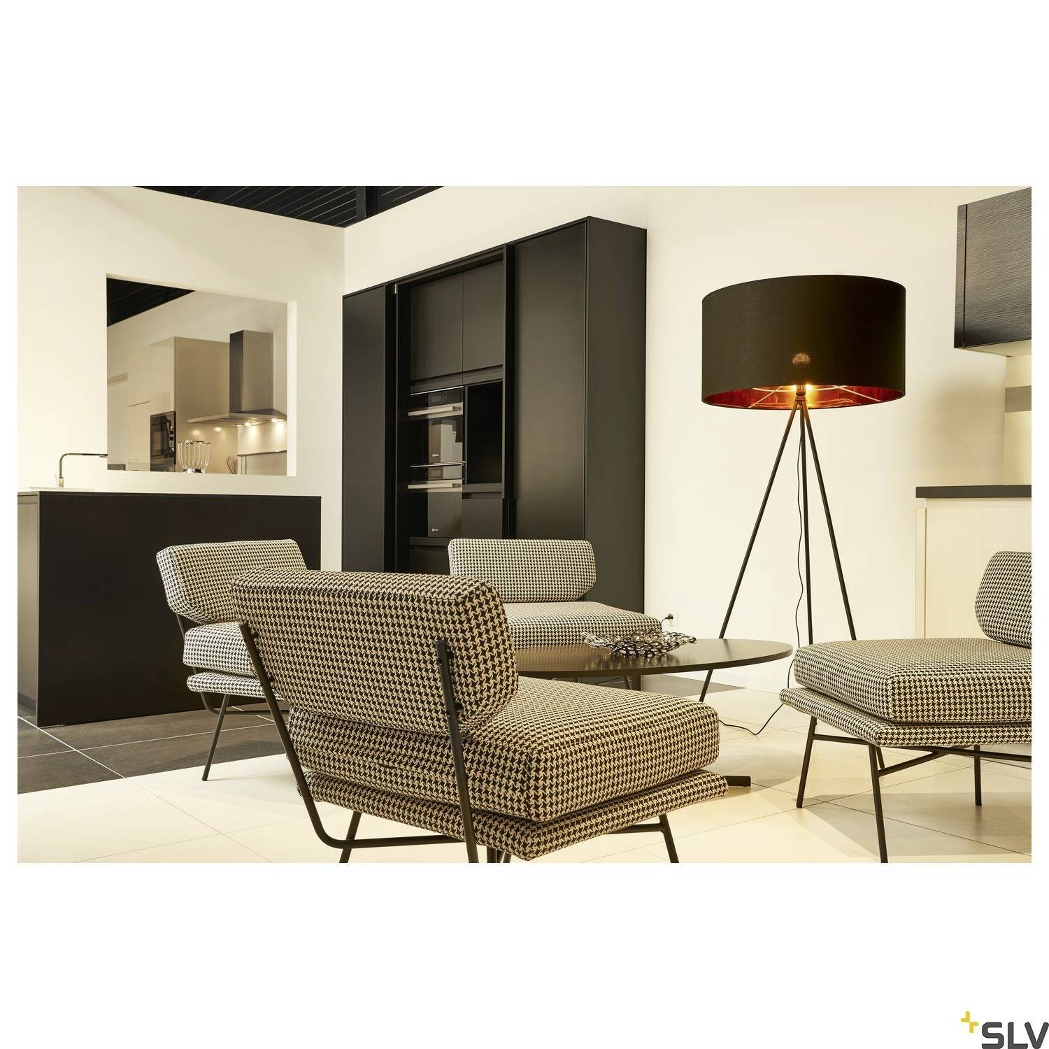 Ein modernes Wohnzimmer mit stilvollem Essbereich, schwarzem Schrank, zwei gepolsterten Stühlen, einem Tisch und einer Stehleuchte.