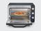 Ein geöffneter Minibackofen mit einer gebackenen Pizza auf dem Rost. Der Ofen hat Drehknöpfe zum Einstellen von Temperatur und Zeit.