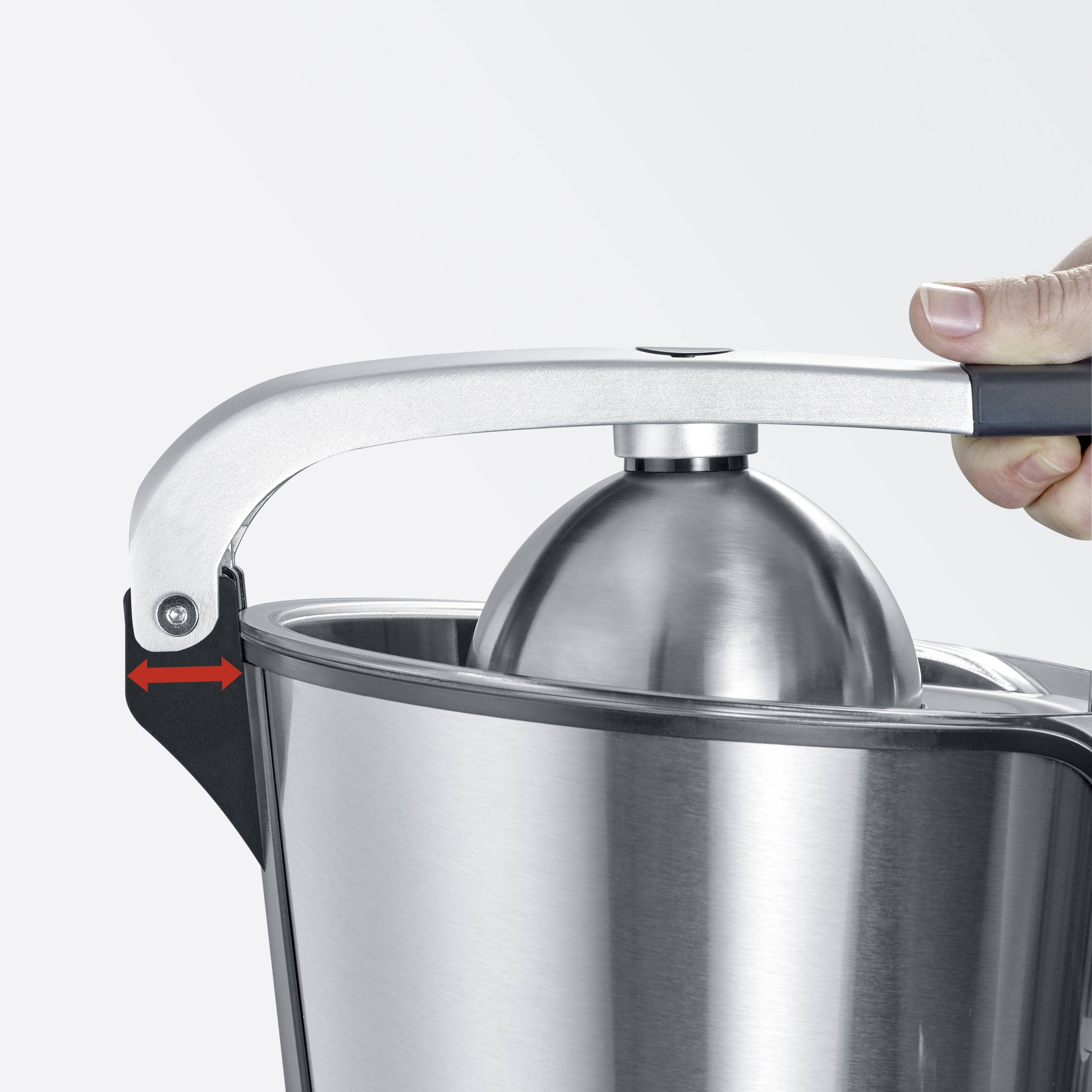 Eine Hand drückt den Hebel einer silbernen Zitruspresse mit einer runden Presskugel. Ein roter Pfeil zeigt die Hebelrichtung an.