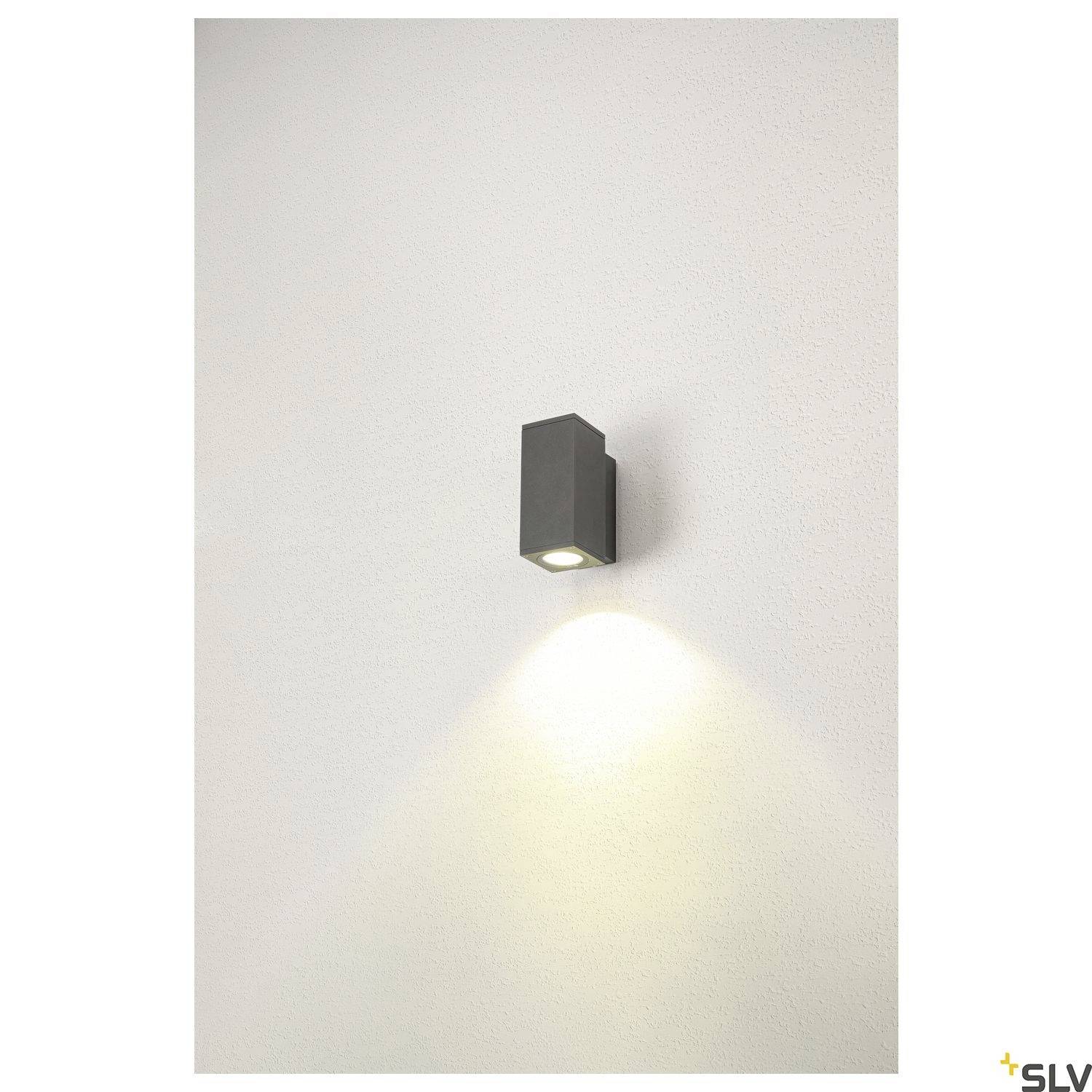 Wandleuchte in modernem Design, spendet nach unten gerichtetes Licht auf einer weißen Wand. Ideal zur stimmungsvollen Beleuchtung.