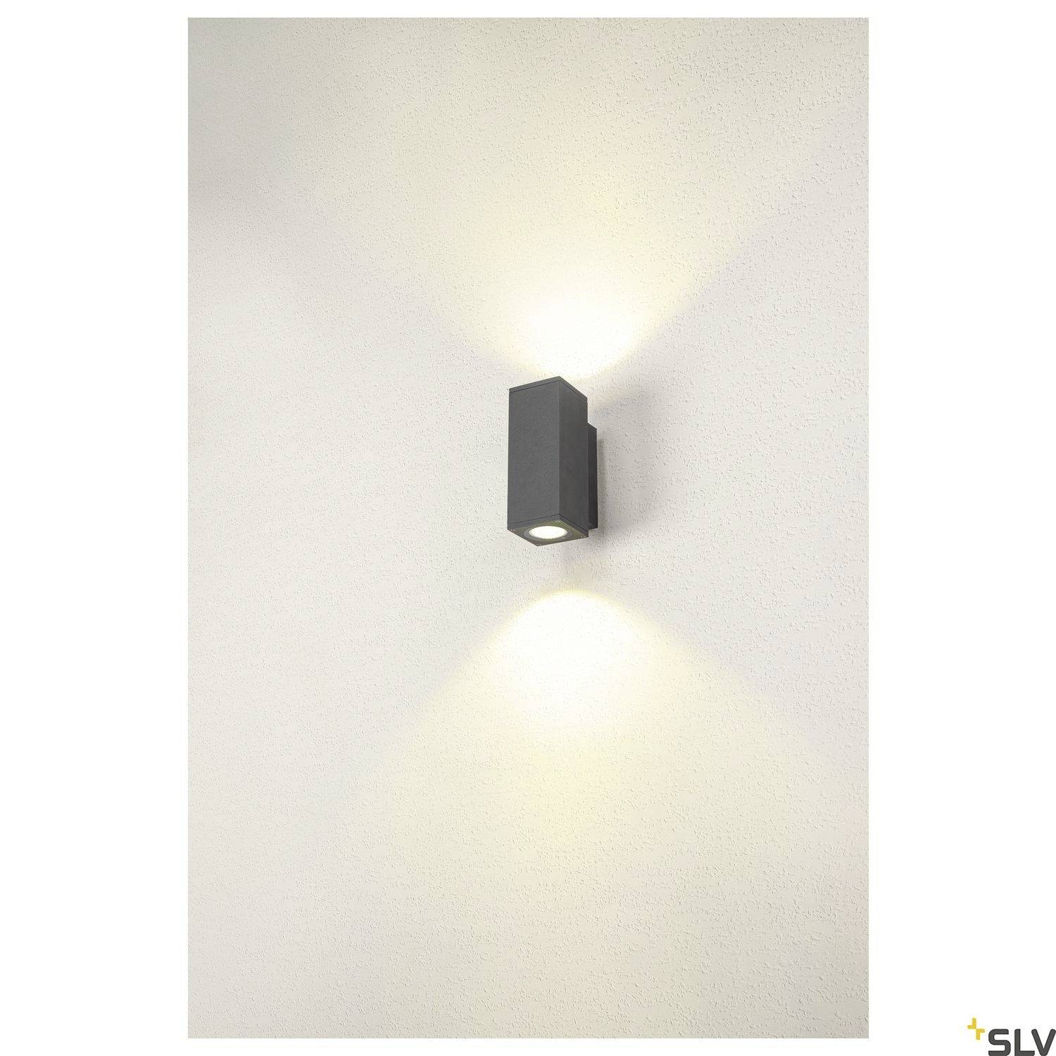 Schwarze Wandleuchte auf weißer Wand, leuchtet nach oben und unten, erzeugt stilvolle Lichtmuster.