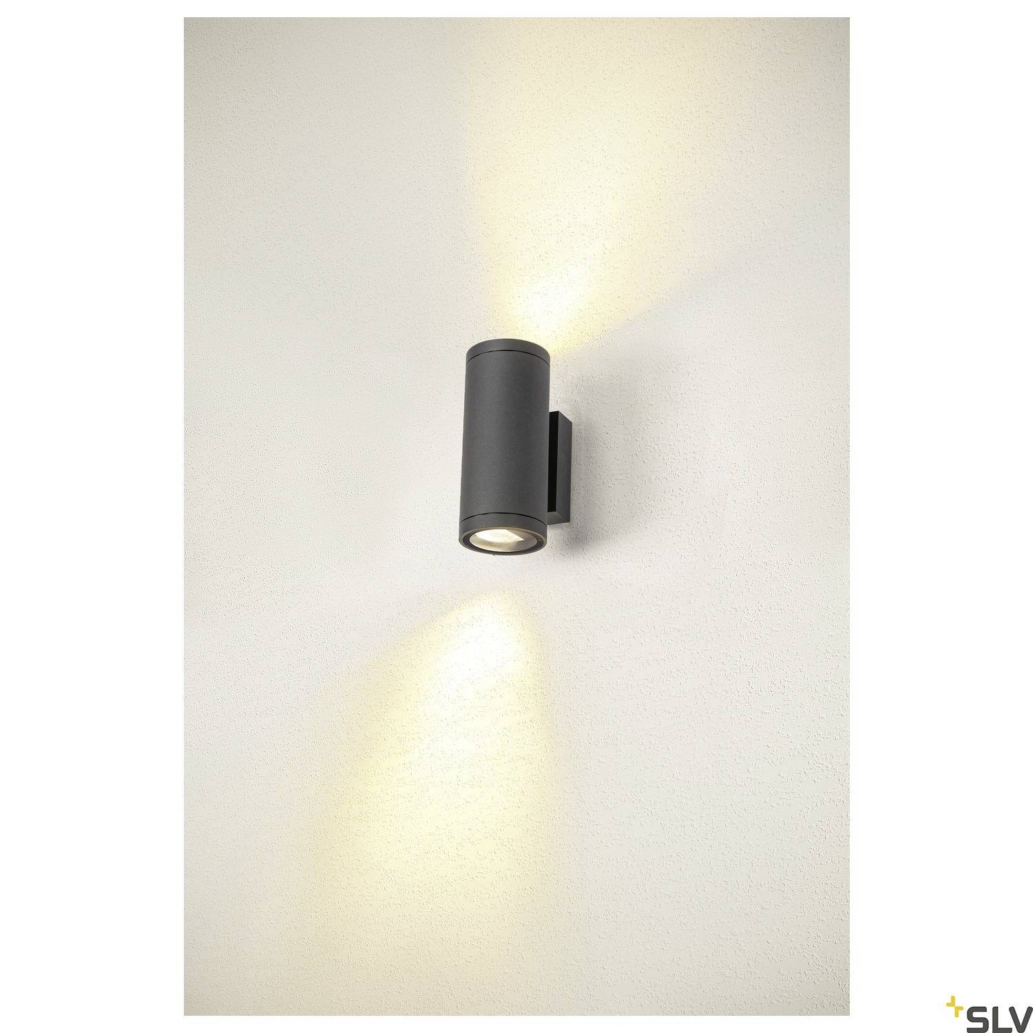Außenwandleuchte in zylindrischer Form, schwarzes Gehäuse mit Up-Down-Lichtstrahl, an einer weißen Wand montiert.