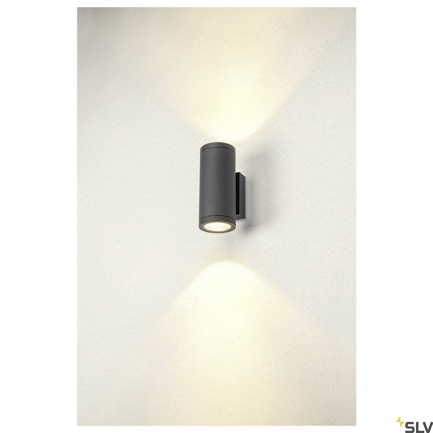 Wandleuchte an einer Wand, erzeugt zwei Lichtkegel – nach oben und unten.