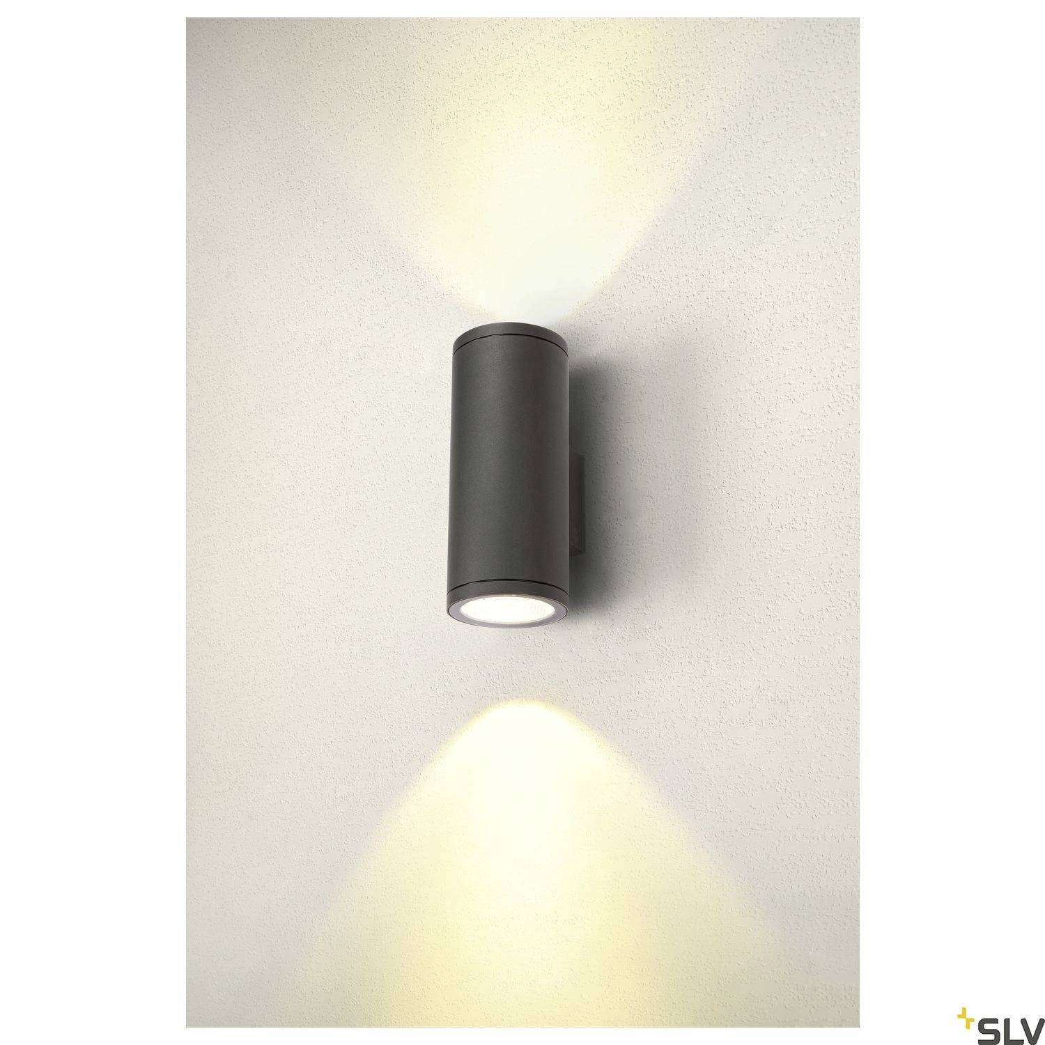 Schwarzgraue Außenwandleuchte mit zylindrischem Design, strahlt Licht nach oben und unten. Montiert auf einer weißen Wand. Ideal für moderne Außenbereiche.