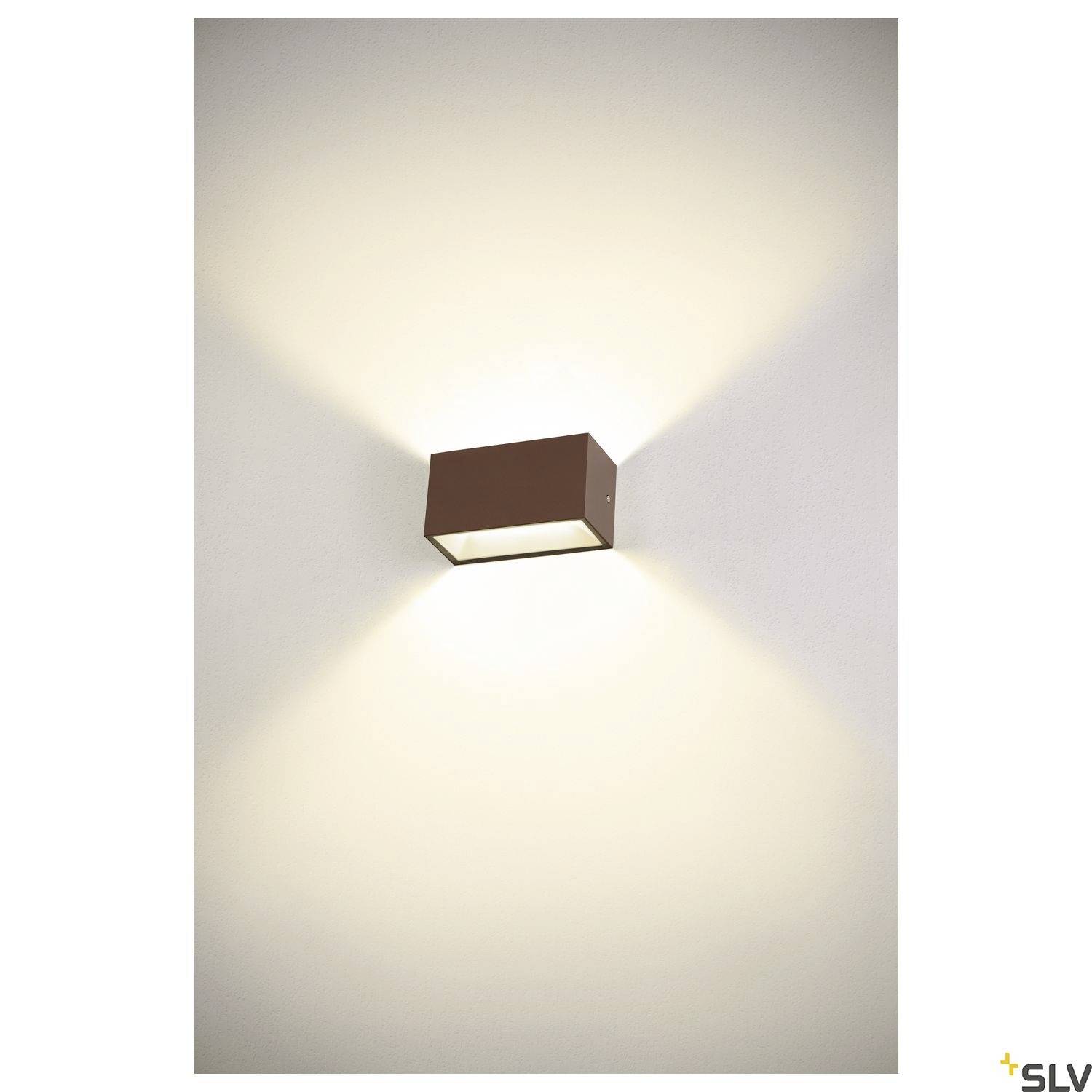 Moderne Wandleuchte im quadratischen Design, montiert auf einer weißen Wand. Sie strahlt warmes Licht nach oben und unten aus.