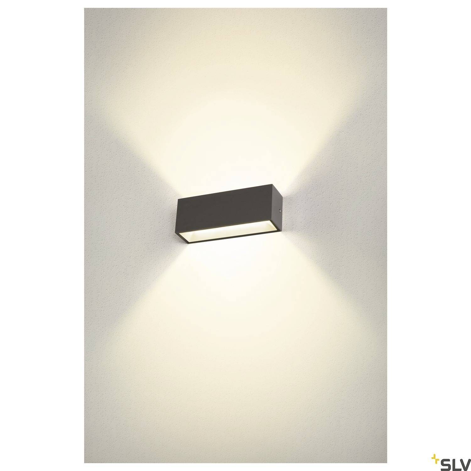 Cube-förmige Wandlampe mit indirekter, kühler weißer Beleuchtung, wirft symmetrisches Lichtmuster nach oben und unten an der Wand.