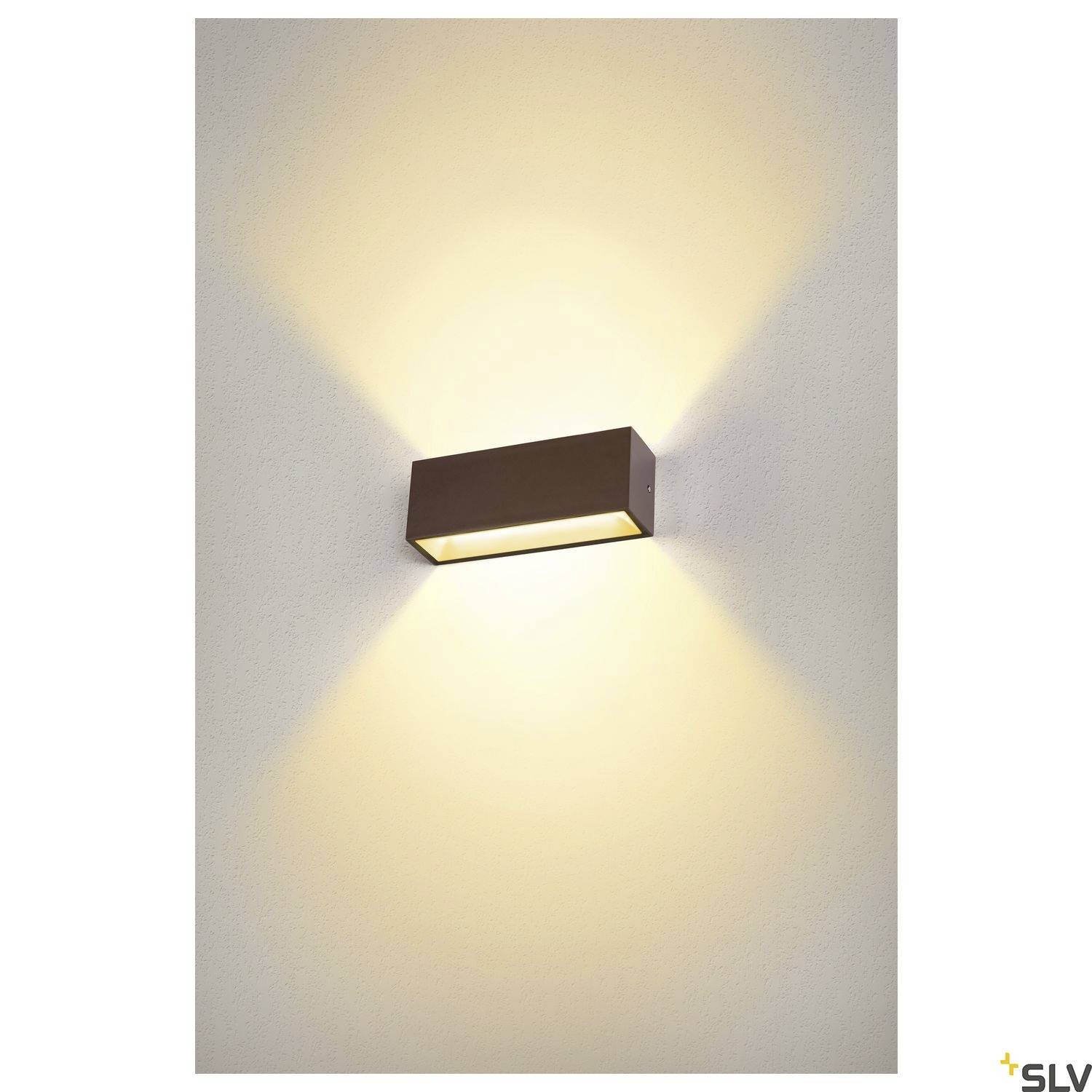 Rechteckige Wandlampe aus Metall, wirft warmes Licht nach oben und unten gegen die Wand, schafft eine einladende Atmosphäre.