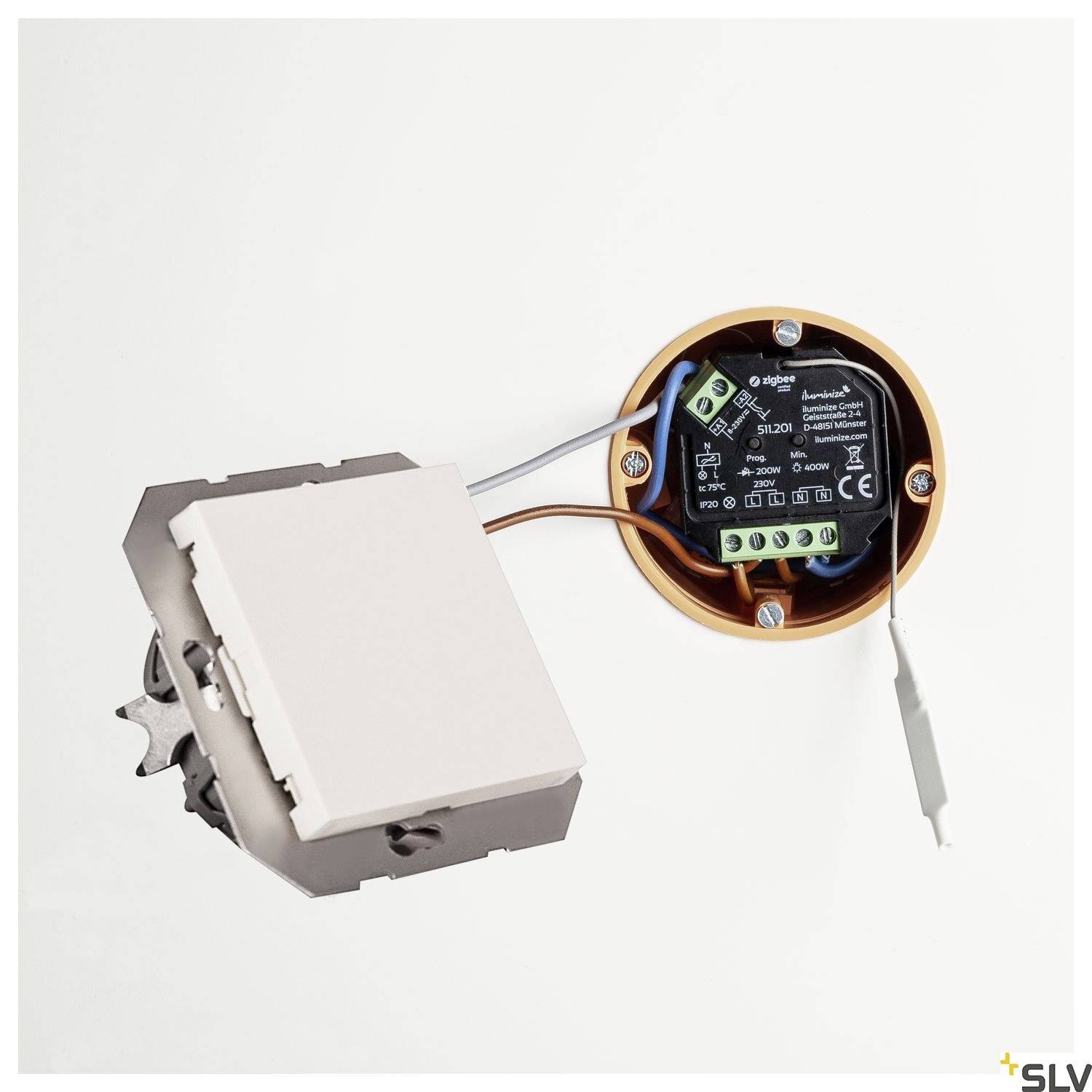 Ein Lichtschalter wird mit einem Batterieempfänger verbunden. Der Empfänger ist rund und hat einen schwarzen Gehäusedeckel.