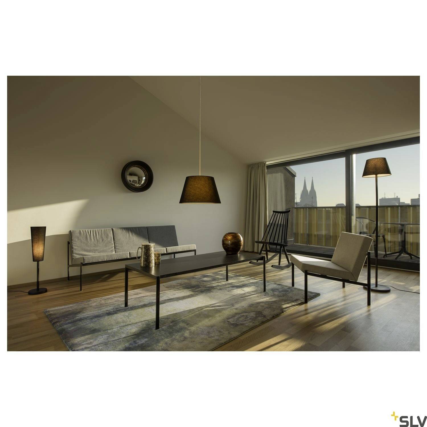Wohnzimmer mit minimalistischem Design: Sofa, Sessel, Kaffeetisch und Stehlampen. Panoramafenster mit Blick auf den Kölner Dom.