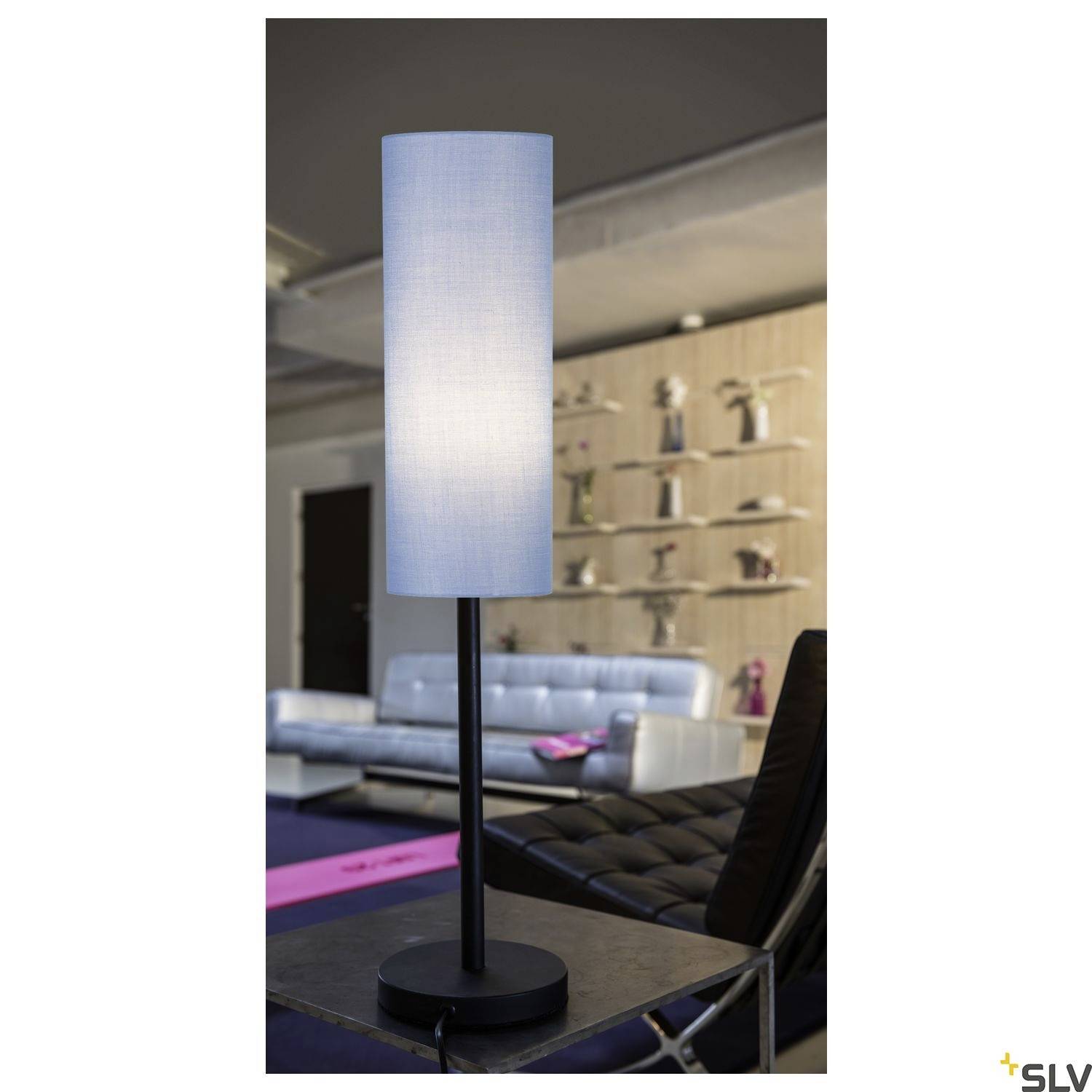 Helles Wohnzimmer mit blauer Stehlampe im Vordergrund. Im Hintergrund ein modernes Sofa, Bücherregale und dekorative Gegenstände.
