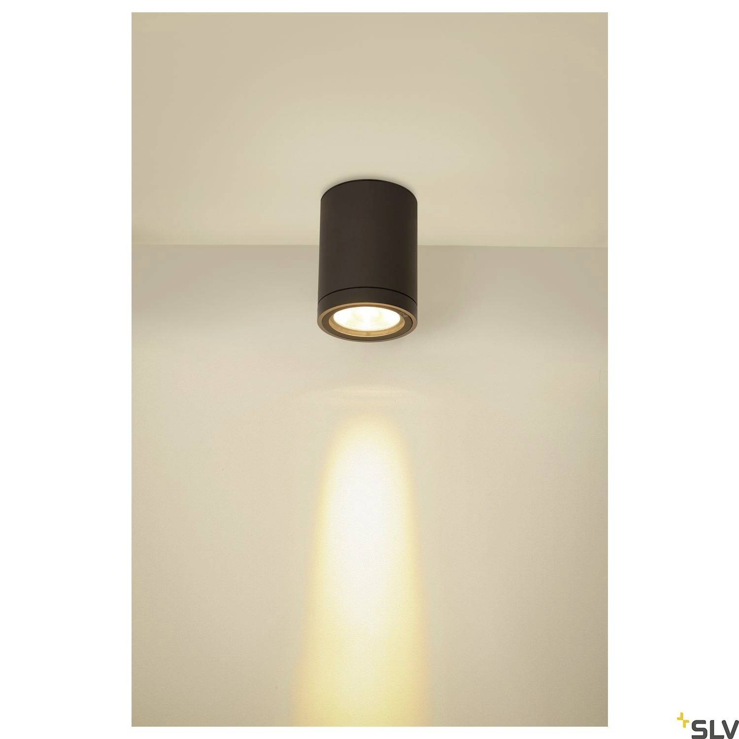 Deckenleuchte mit zylindrischem Gehäuse, aus der warmes, fokussiertes Licht strahlt, das einen kreisförmigen Lichtkegel erzeugt.