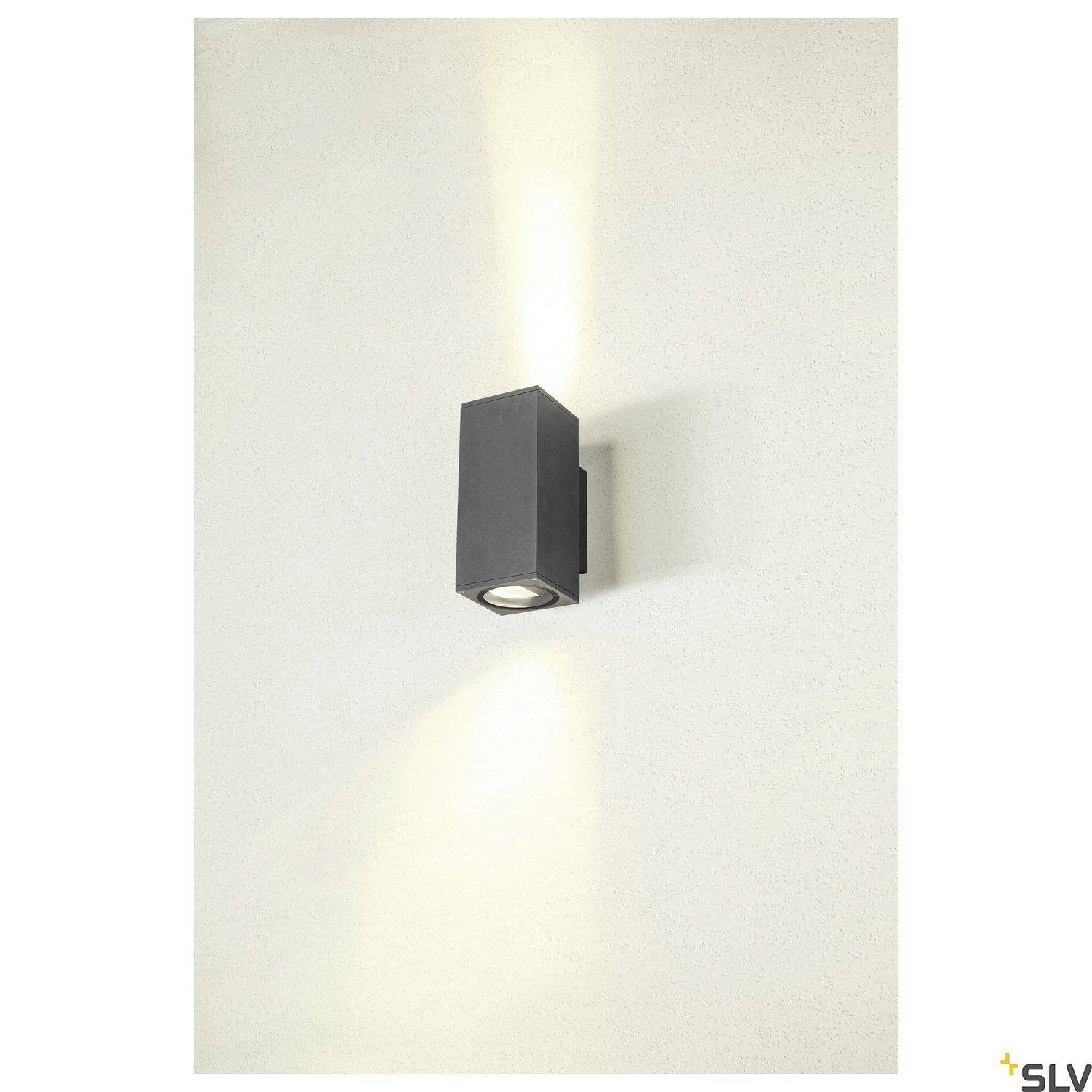 Wandlampe mit modernem, schwarzem, rechteckigem Design. Strahlt Licht nach oben und unten an einer cremeweißen Wand aus.