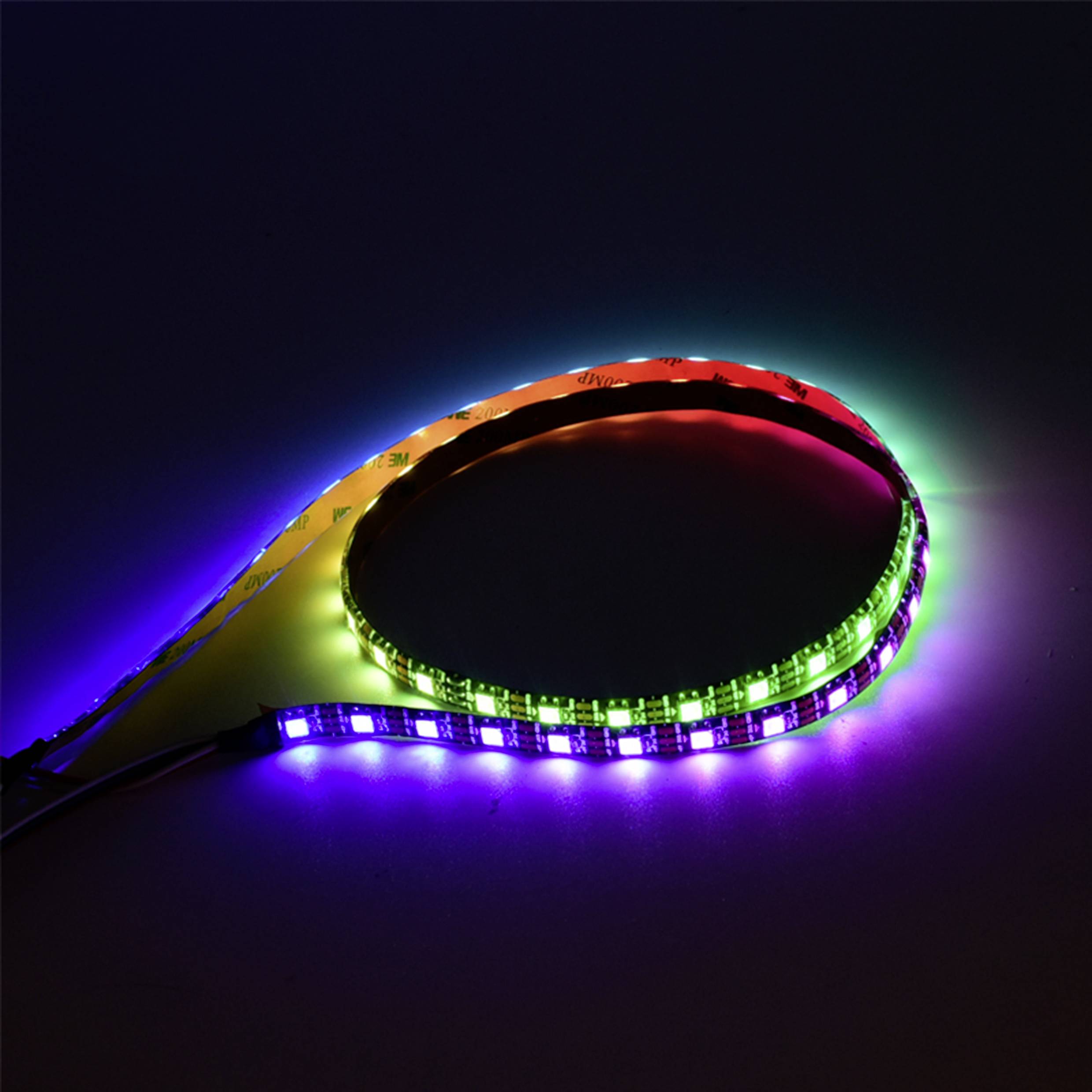 LED-Streifen in verschiedenen Farben leuchten auf dunklem Hintergrund. Sie bilden eine Schleife und erzeugen ein buntes Lichtspiel.