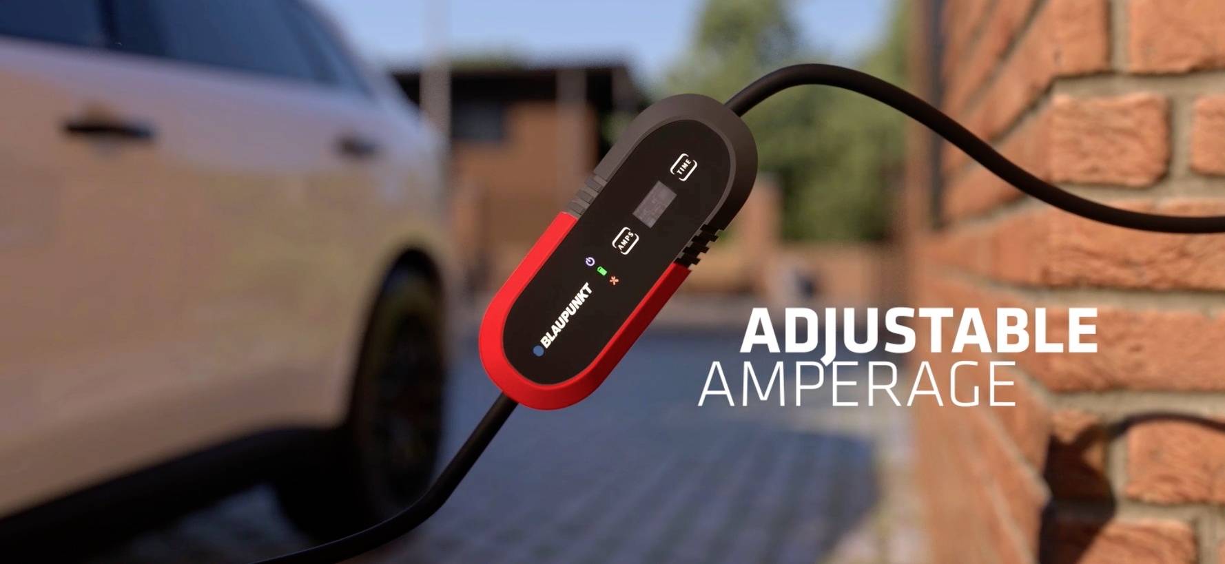 Ein Auto-Ladekabel mit verstellbarem Amperwert ist an einem Fahrzeug angeschlossen. Im Hintergrund eine Backsteinmauer.