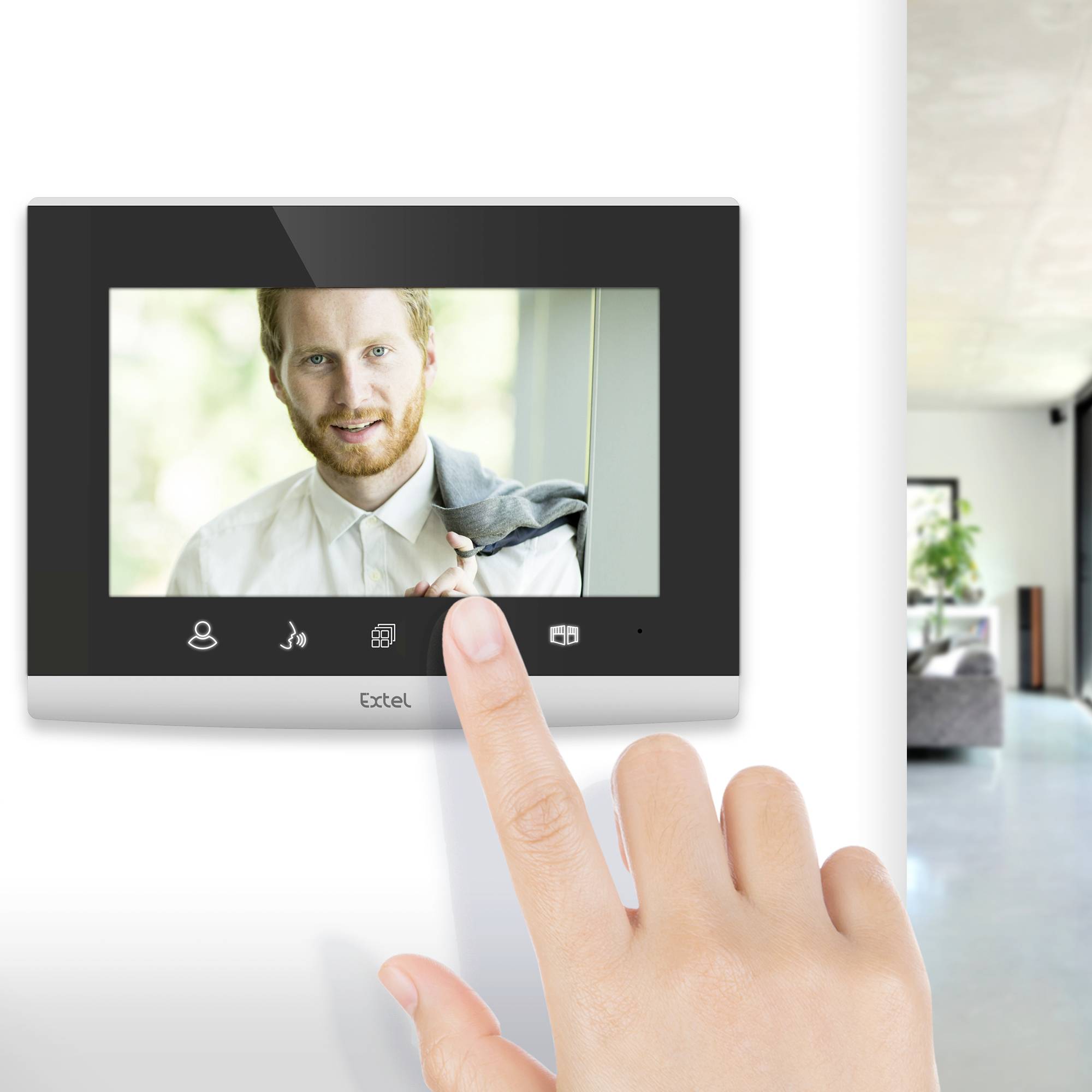 Eine Hand berührt ein Bildschirm-Intercom an einer Wand. Auf dem Bildschirm ist das Bild einer Person sichtbar, die draußen steht.