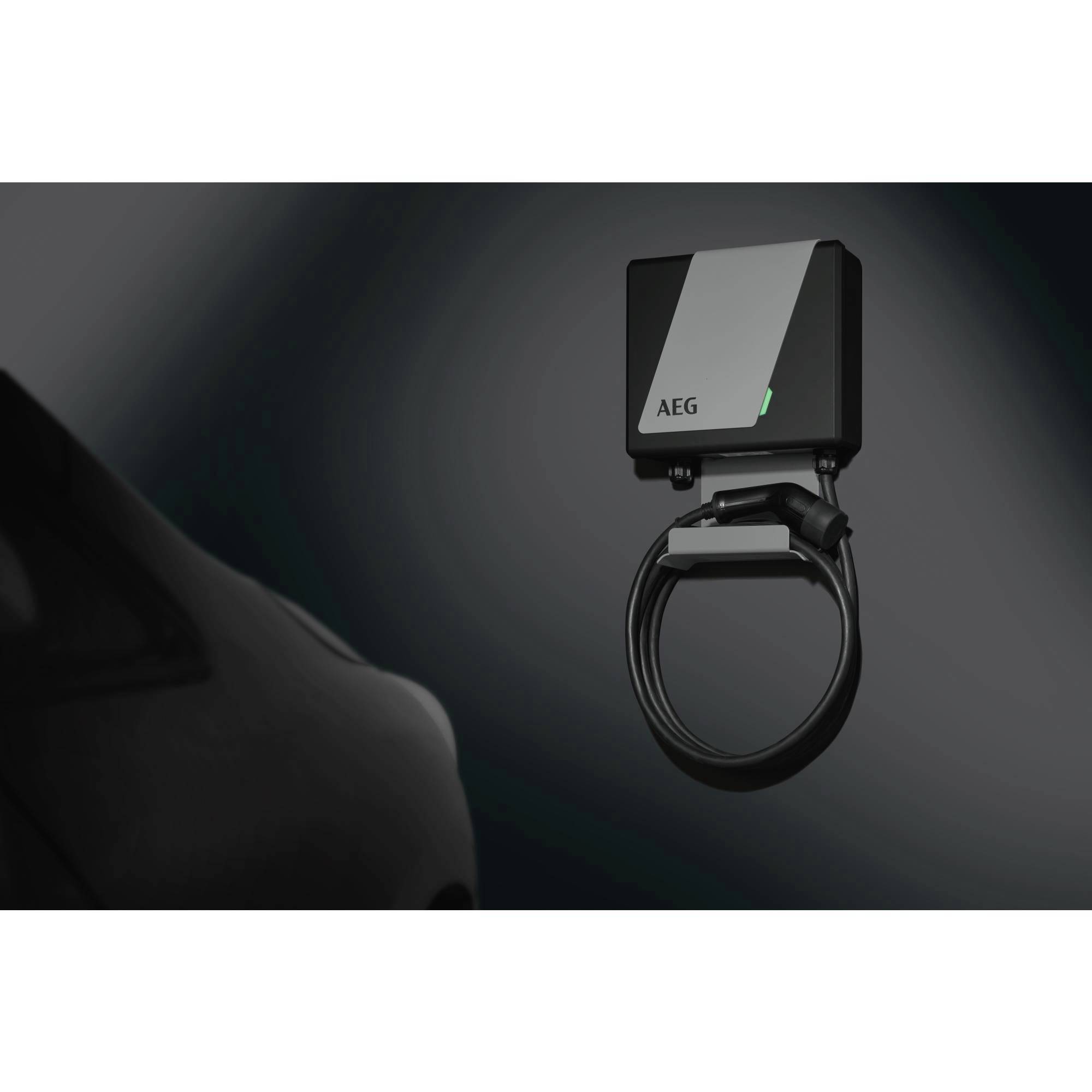 Ein schwarzes Elektroauto wird von einer an der Wand montierten AEG-Ladestation aufgeladen.