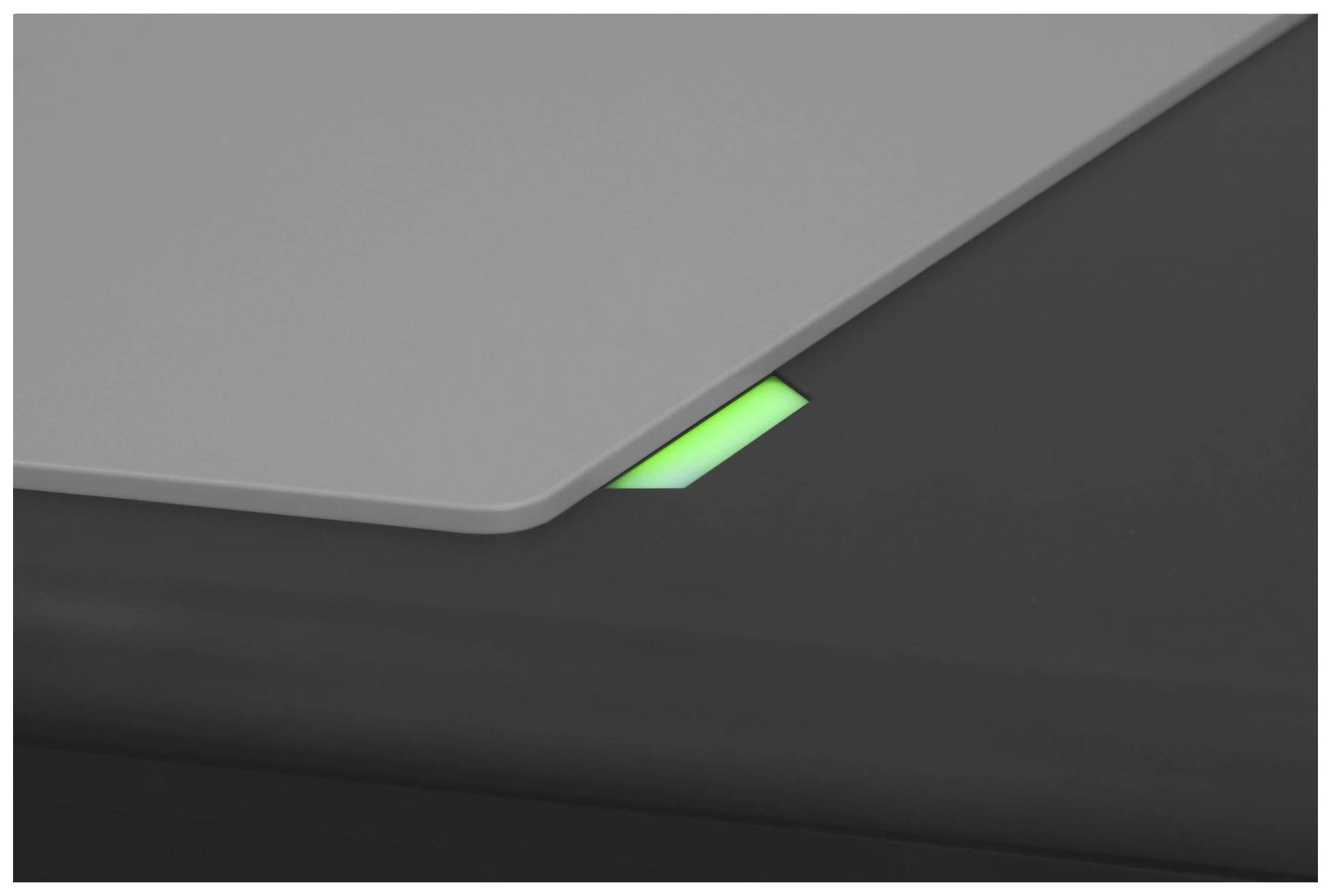 Ecke eines Laptops mit grün leuchtender Anzeige auf einer dunklen Oberfläche.