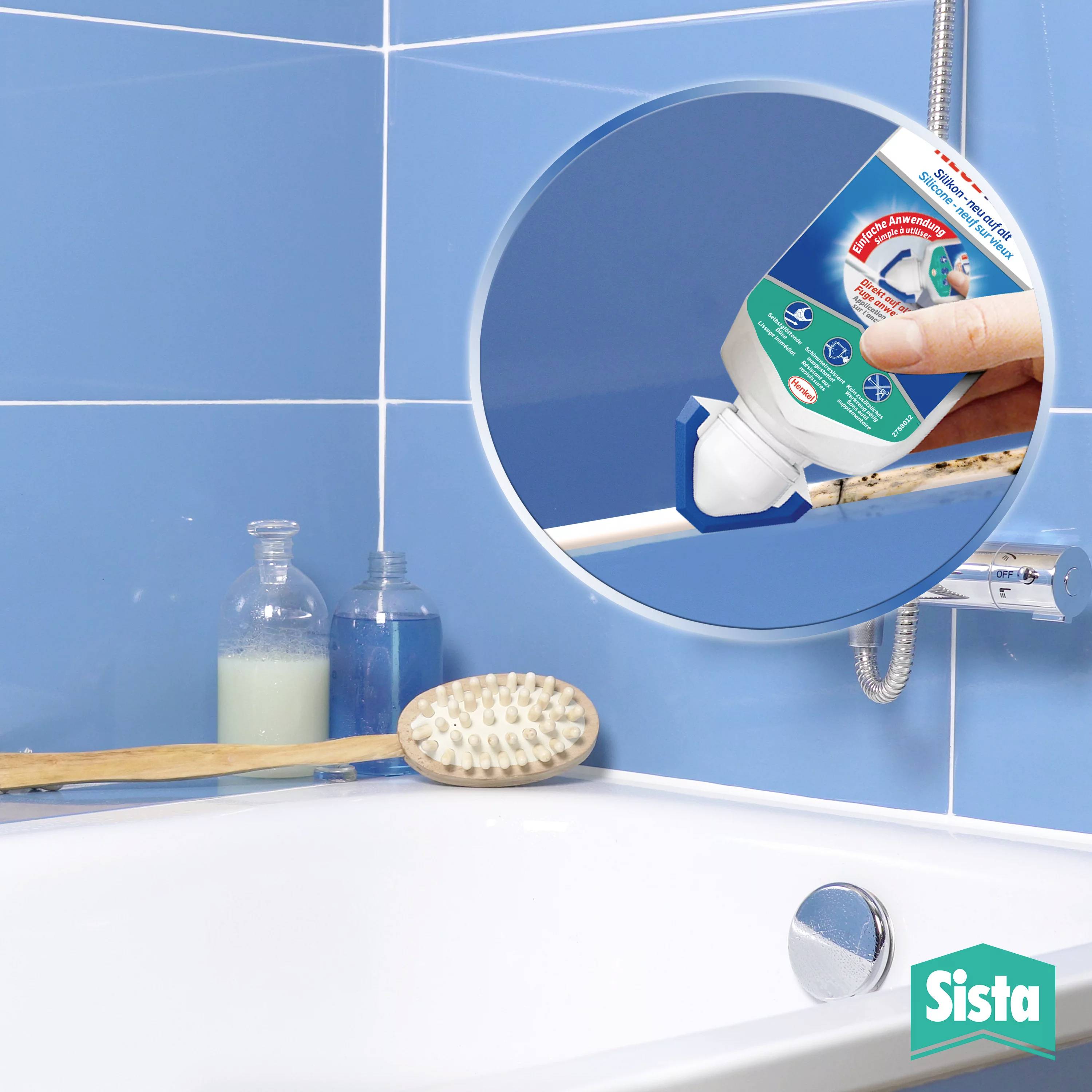 Eine Hand trägt eine Tube Dichtmittel auf die Badewannenfugen auf, um Schimmelbildung zu verhindern. Im Badezimmer sind Fliesen zu sehen.