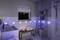 Modernes Badezimmer bei Nacht mit blauer LED-Beleuchtung. Ein Waschbecken, ein Handtuchregal und Kerzen sorgen für eine entspannte Atmosphäre.