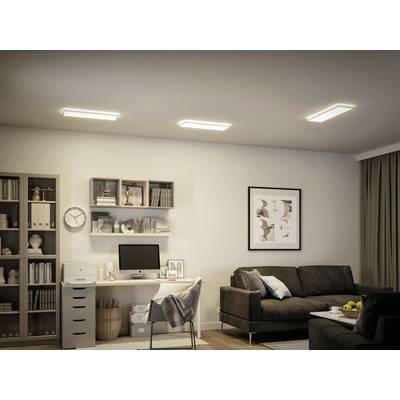 Wohnzimmer mit Schreibtisch, Regal und Sofa. Computermonitor und Dekorationen auf dem Schreibtisch, Regale mit Büchern.