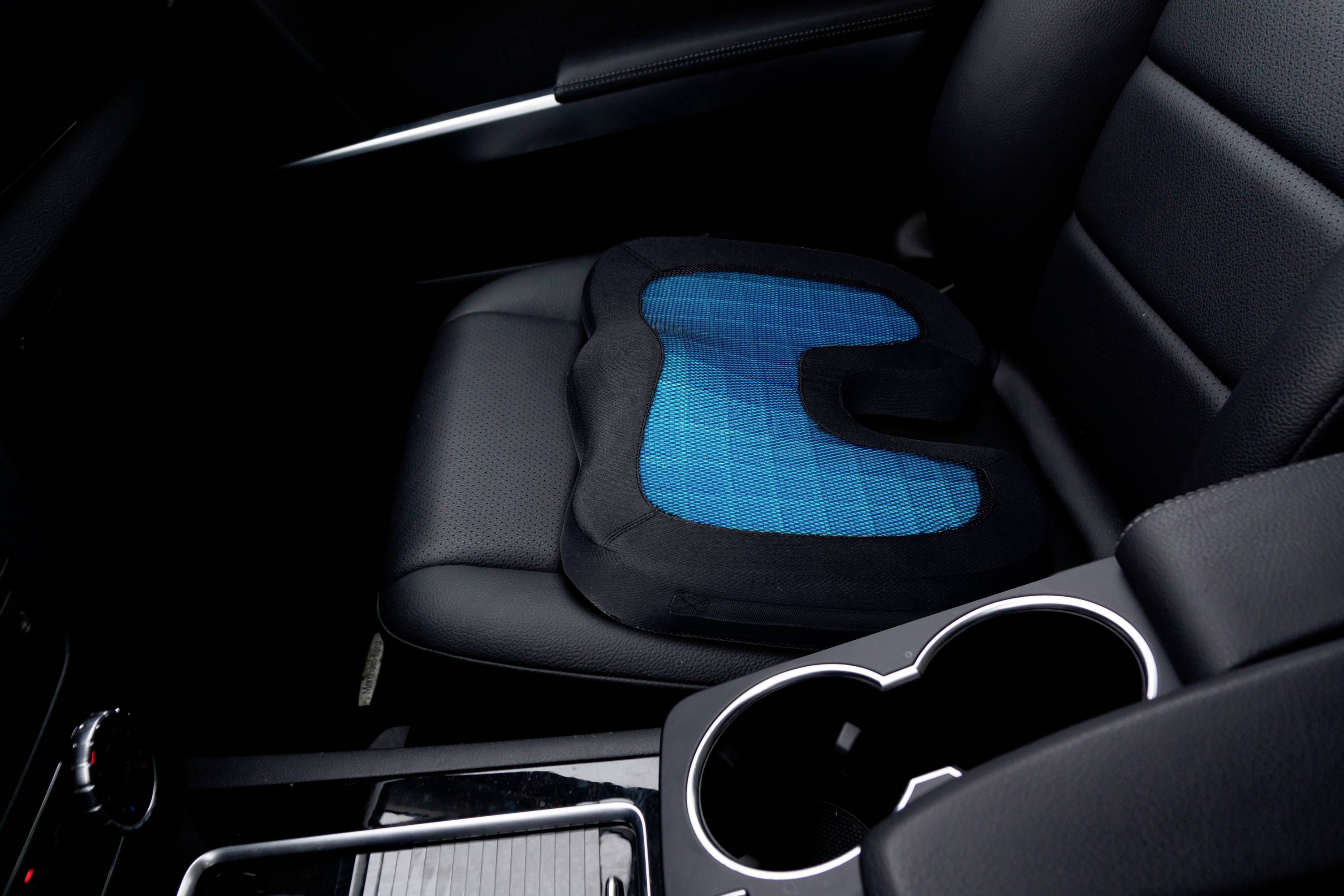 Autositz mit blauem ergonomischem Sitzkissen, das Komfort und Unterstützung beim Fahren bietet. Geeignet für lange Fahrten.