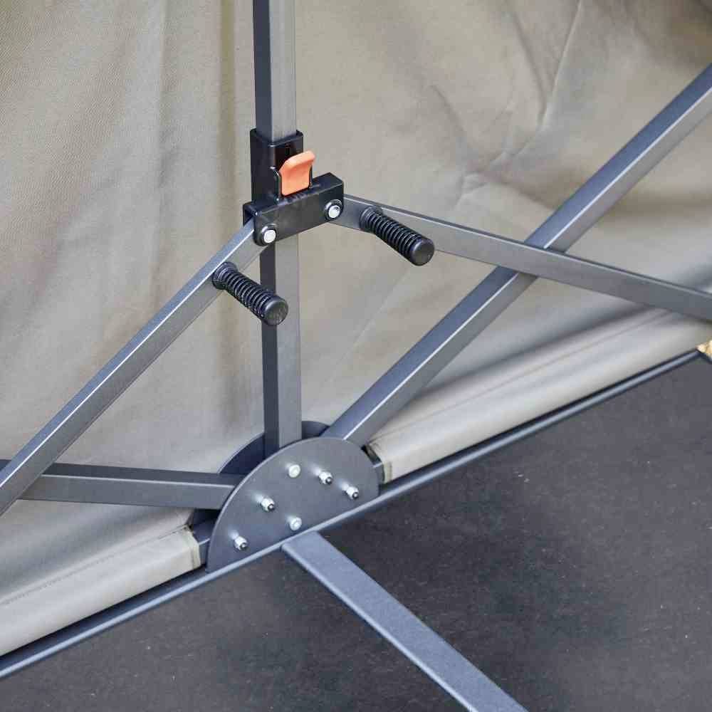 Ein stabiler, metallischer Klappmechanismus eines Regenschirms, mit einem roten Verschlussknopf und gerundeten Griffen.