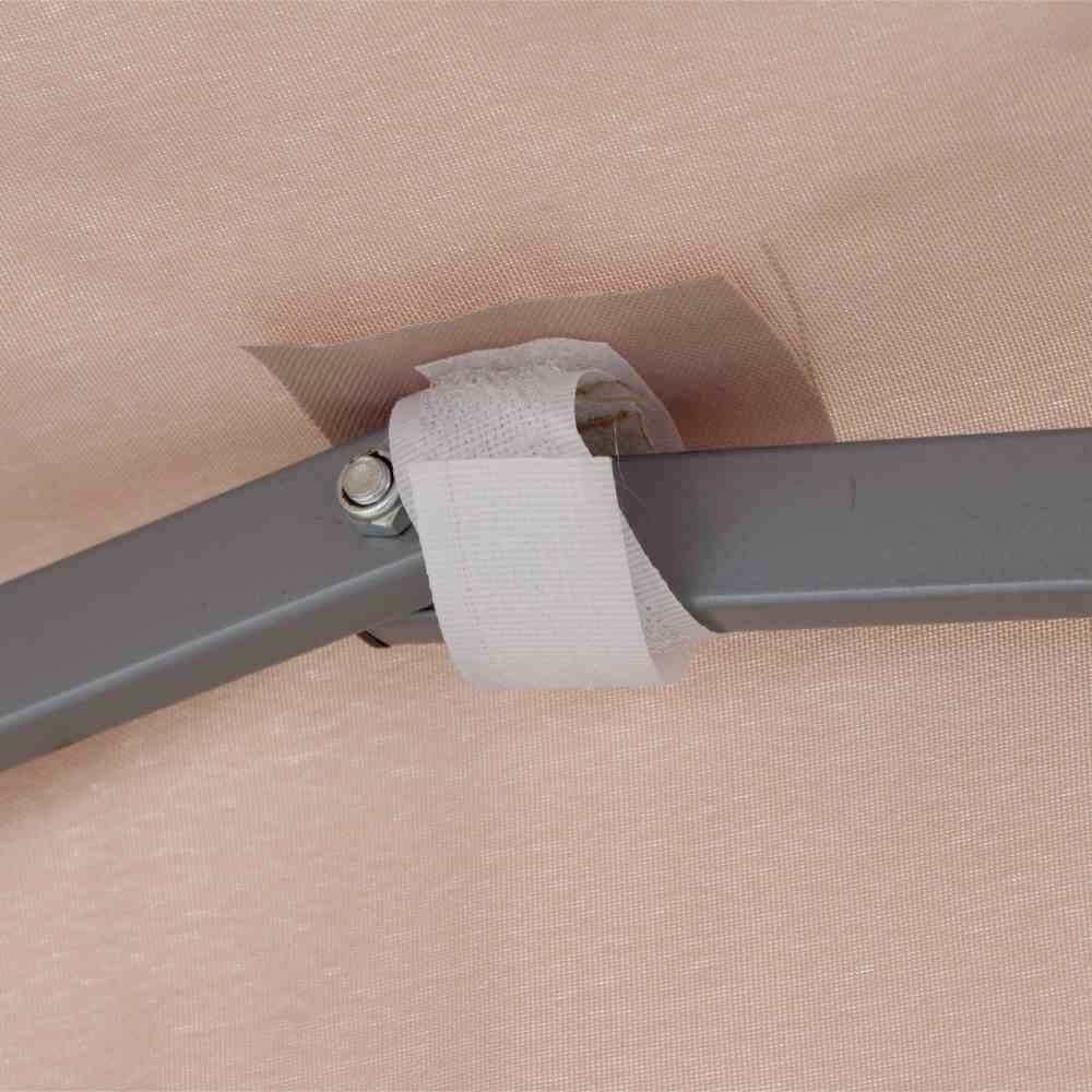 Nahaufnahme eines grauen Metallbügels, befestigt mit weißem Klebeband an einer hellbraunen Oberfläche im Hintergrund.