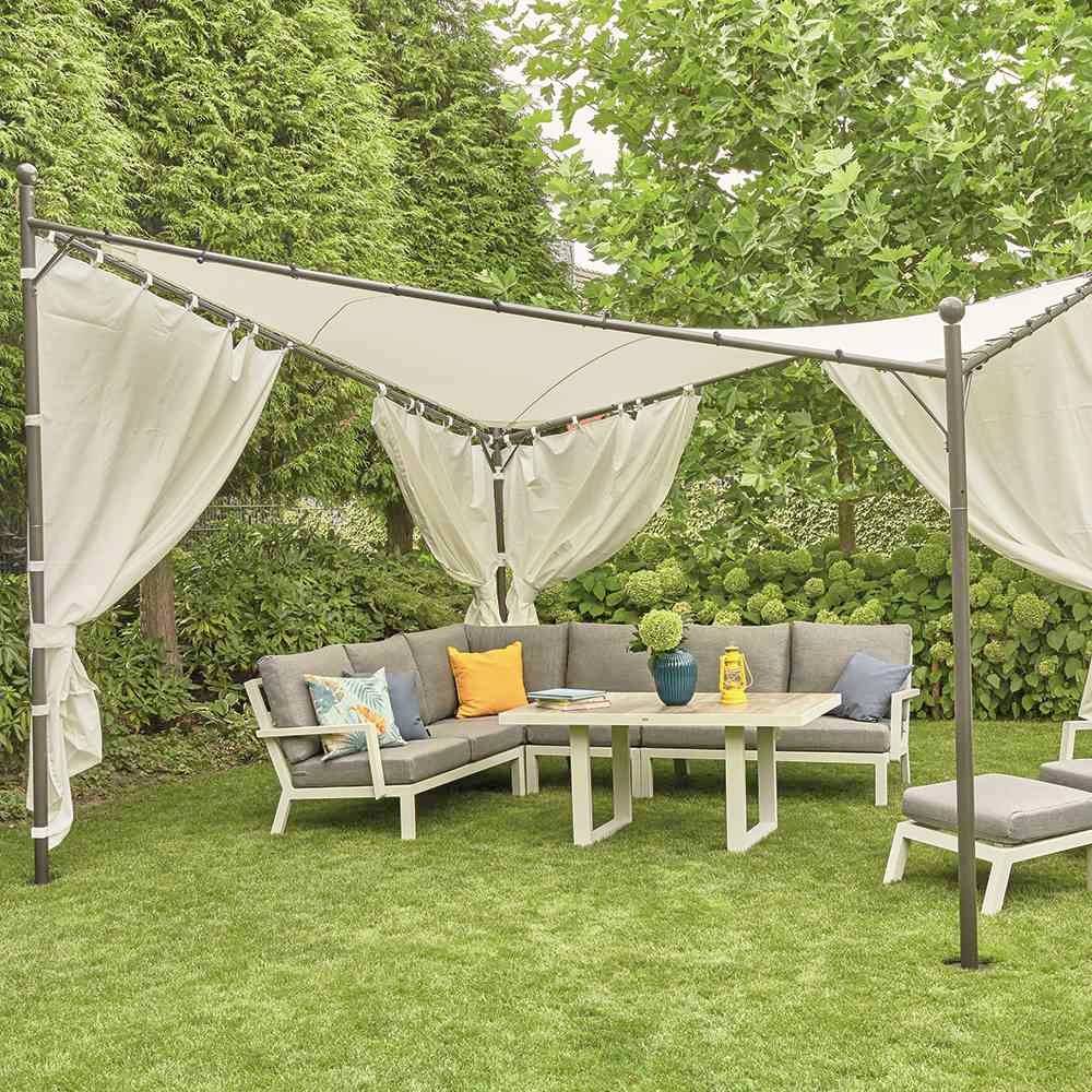 Sitzecke im Garten mit L-förmigem Sofa, Tisch, Kissen und Sonnenschutz. Umgeben von Bäumen und Sträuchern im Grünen.