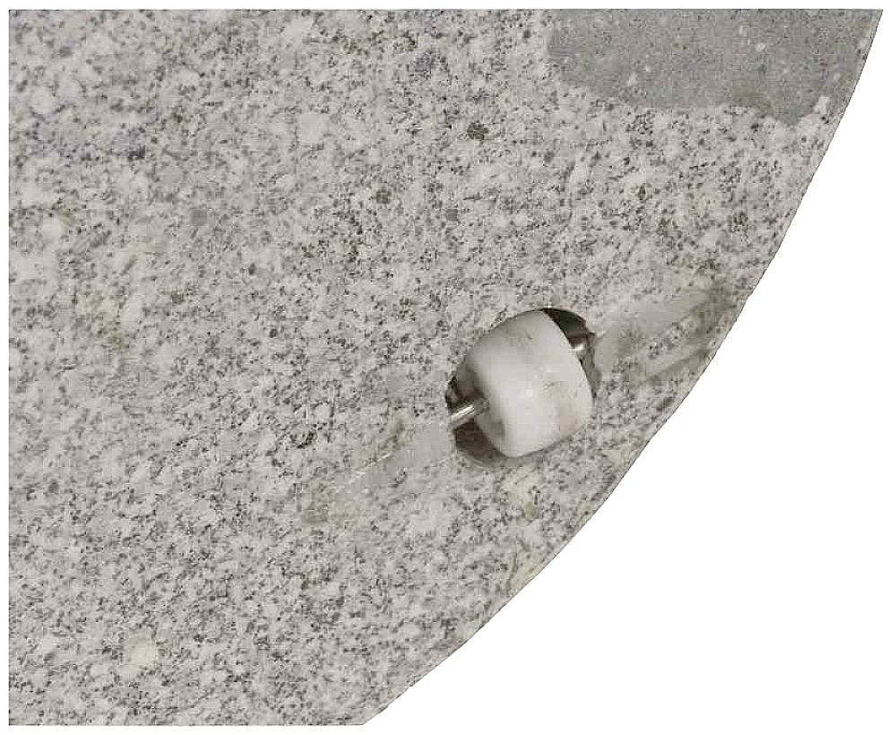 Nahaufnahme einer rauen, grauen Oberfläche mit einer kleinen, runden, weißen und metallischen Befestigungsvorrichtung.