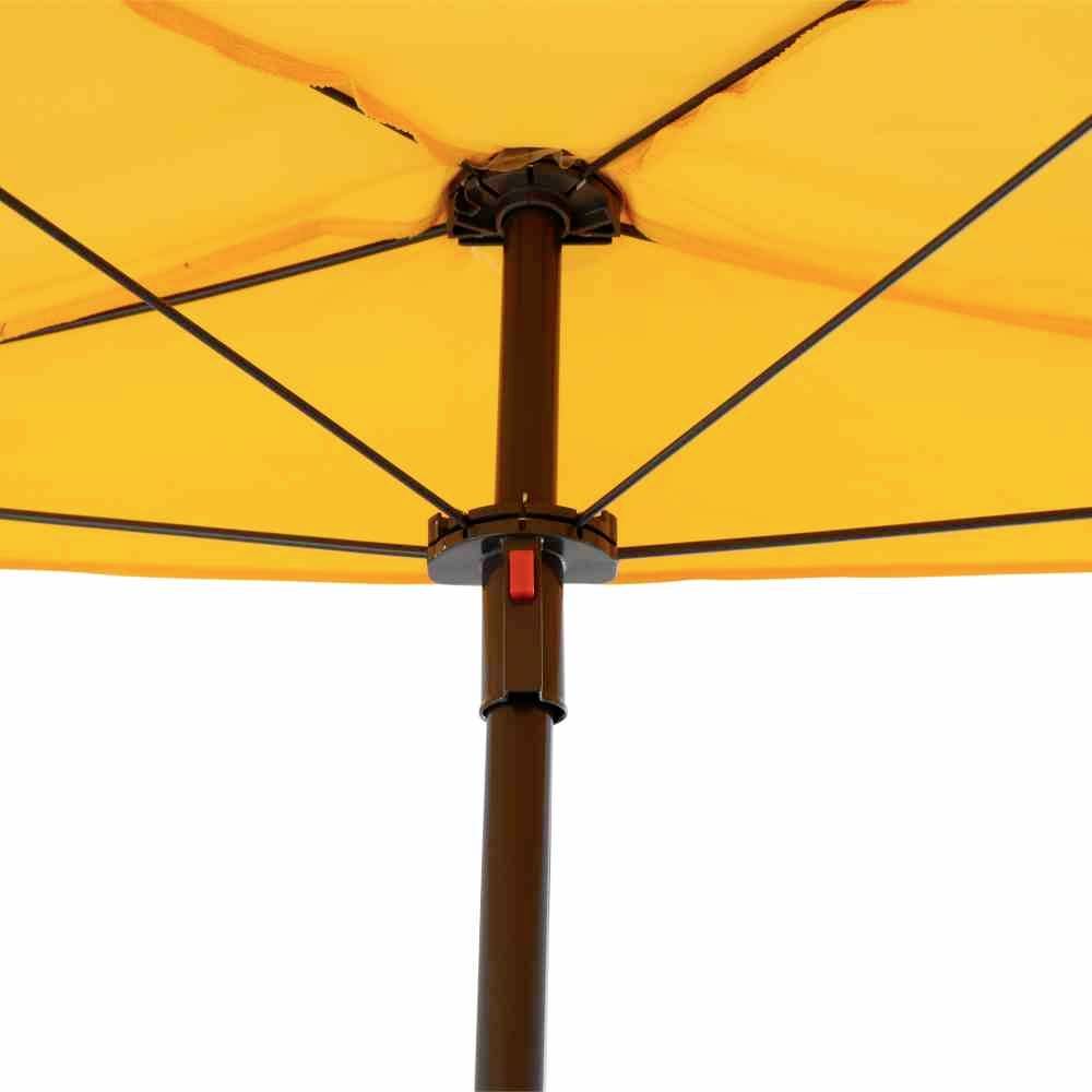 Gelber Sonnenschirm aus der Unteransicht. Schwarze Streben und ein dunkelbrauner Schirmmast sind sichtbar.
