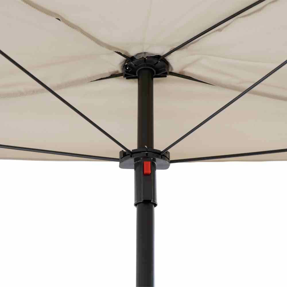 Nahaufnahme eines Sonnenschirms zeigt die Streben und den zentralen Kippmechanismus unter dem beigefarbenen Schirmdach.