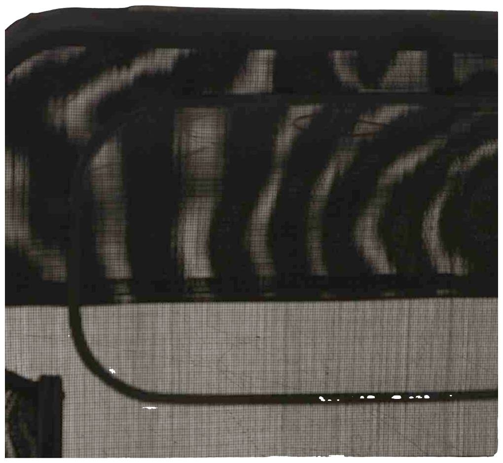 Schwarze, wellenförmige Muster auf einem feinen Netzgewebe mit einem gebogenen Draht im Vordergrund. Dunkle und abstrakte Optik.