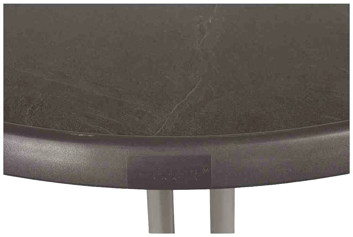 Ein Tisch mit dunkler, glatter Oberfläche und runden Kanten; zwei Beine sind teilweise sichtbar.